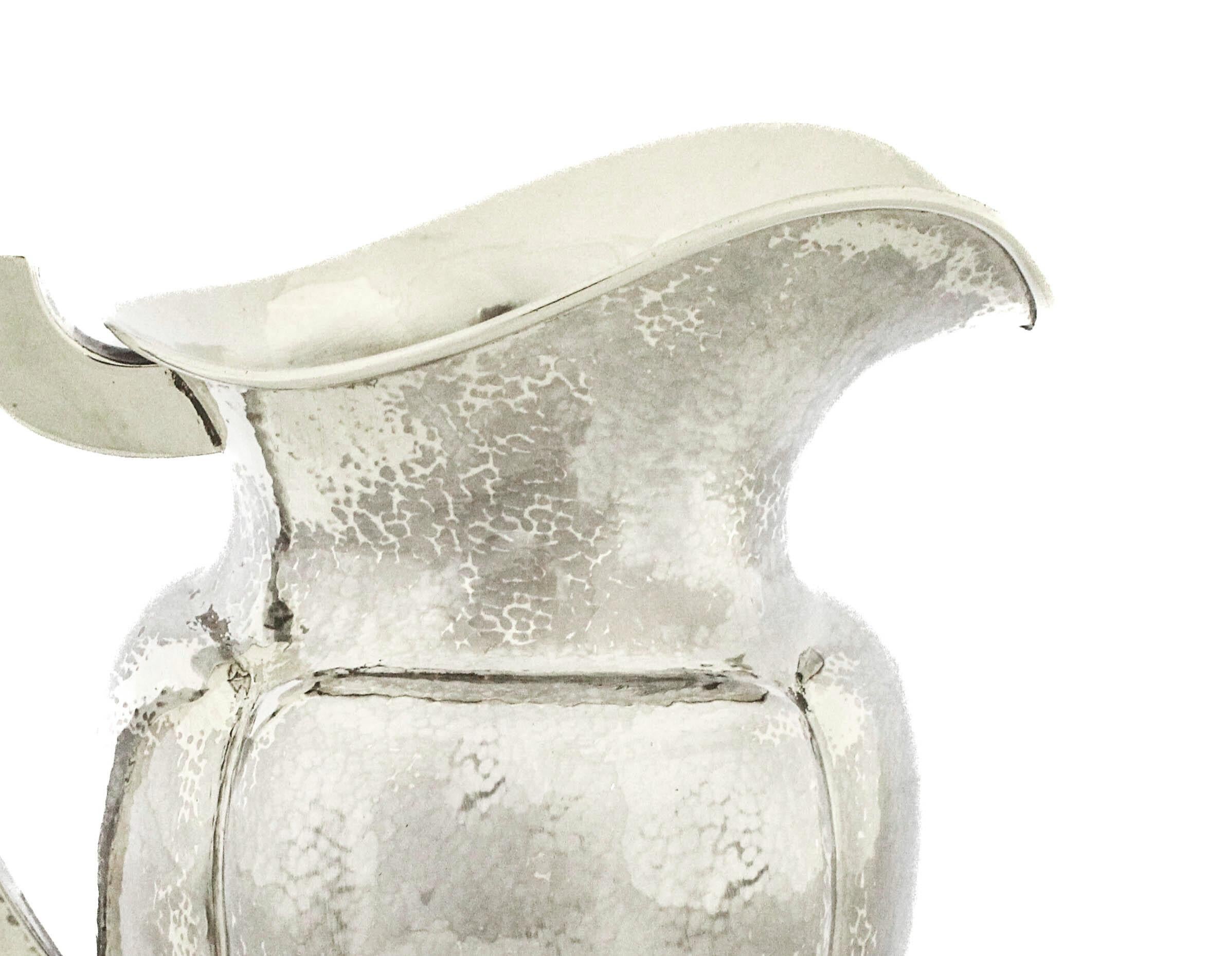 An impressive and beautifully executed sterling silver water pitcher by The Merrill Shop, standing 10 inches tall and designed in the distinctive Craftsman (Arts & Crafts) style. The pitcher features a hand-hammered surface throughout, giving it a