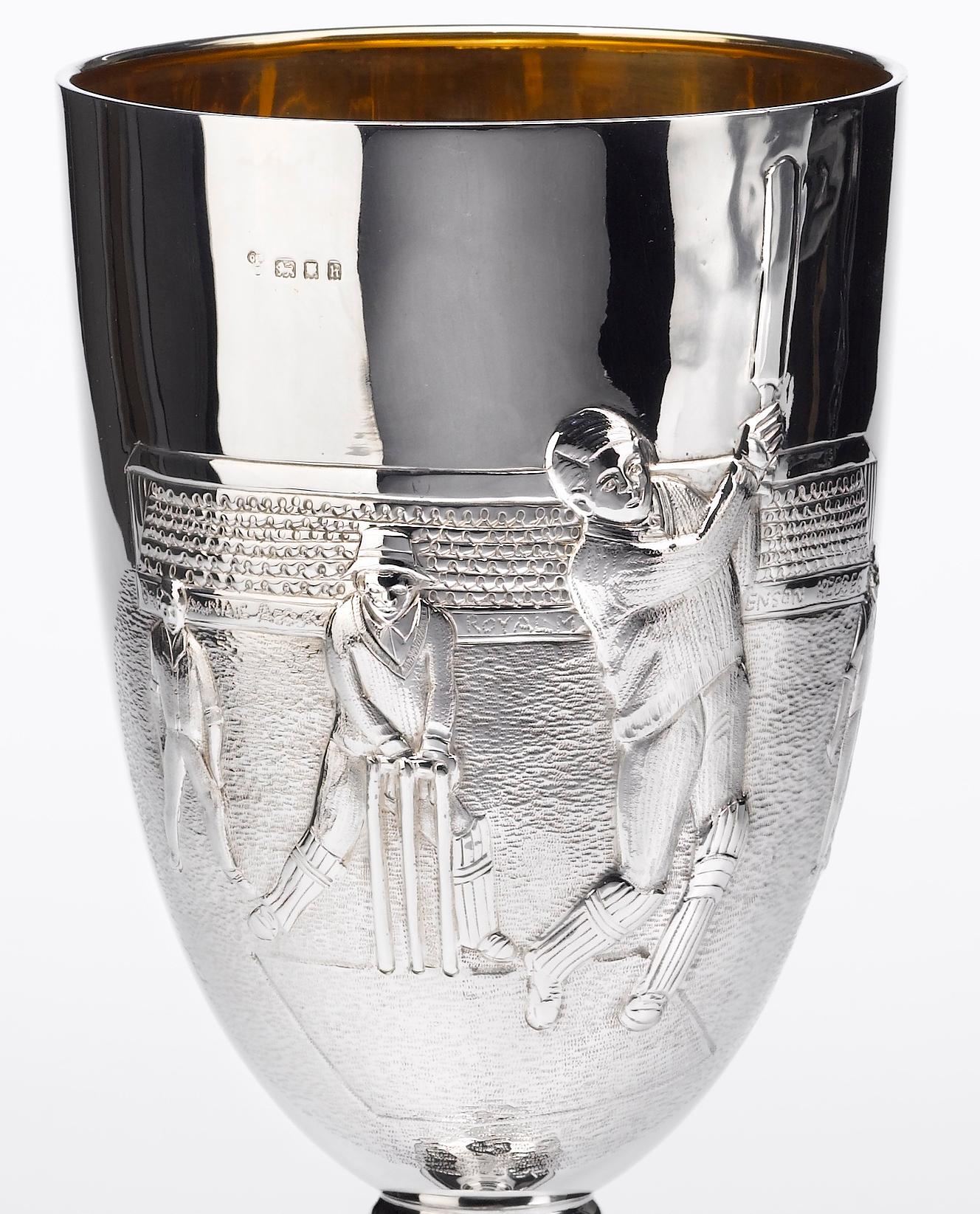 Il s'agit d'un beau trophée en argent sterling datant d'environ 1923. Le trophée en forme de gobelet est décoré en relief d'une scène de cricket énergique. Elle montre un batteur de cricket en train de s'enrouler et de faire un swing, ainsi que des