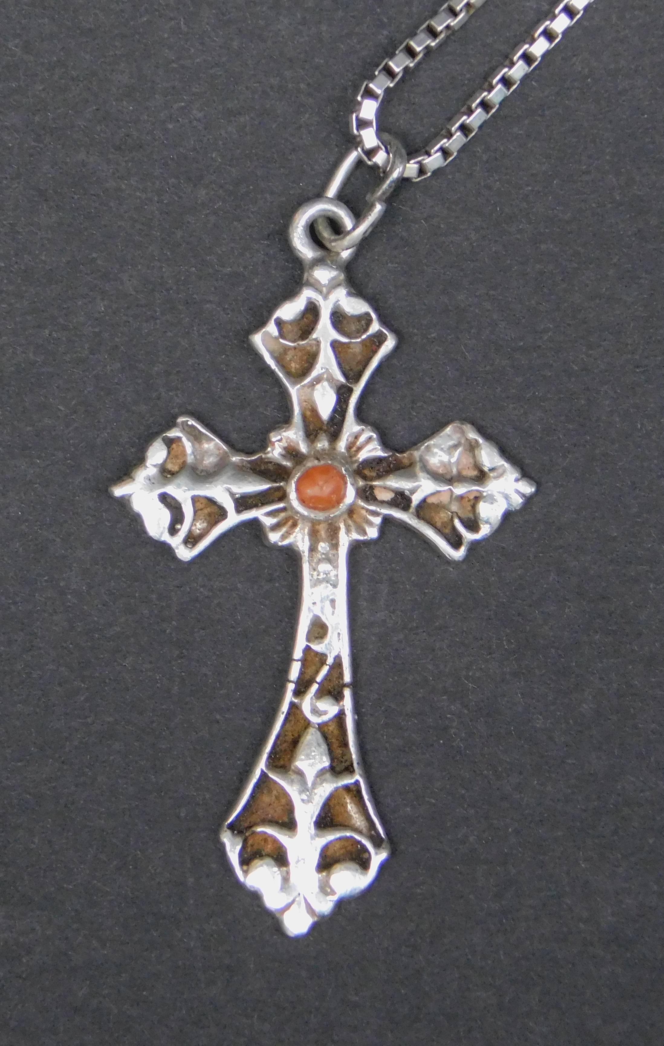 A very elegant sterling silver cross with a small red coral center inset symbolising the blood of Christ. The pendant is from the 1930's and is hung on a sterling silver box chain from the 1970's.
cross=3.50 x2 cm
chain=45 cm long