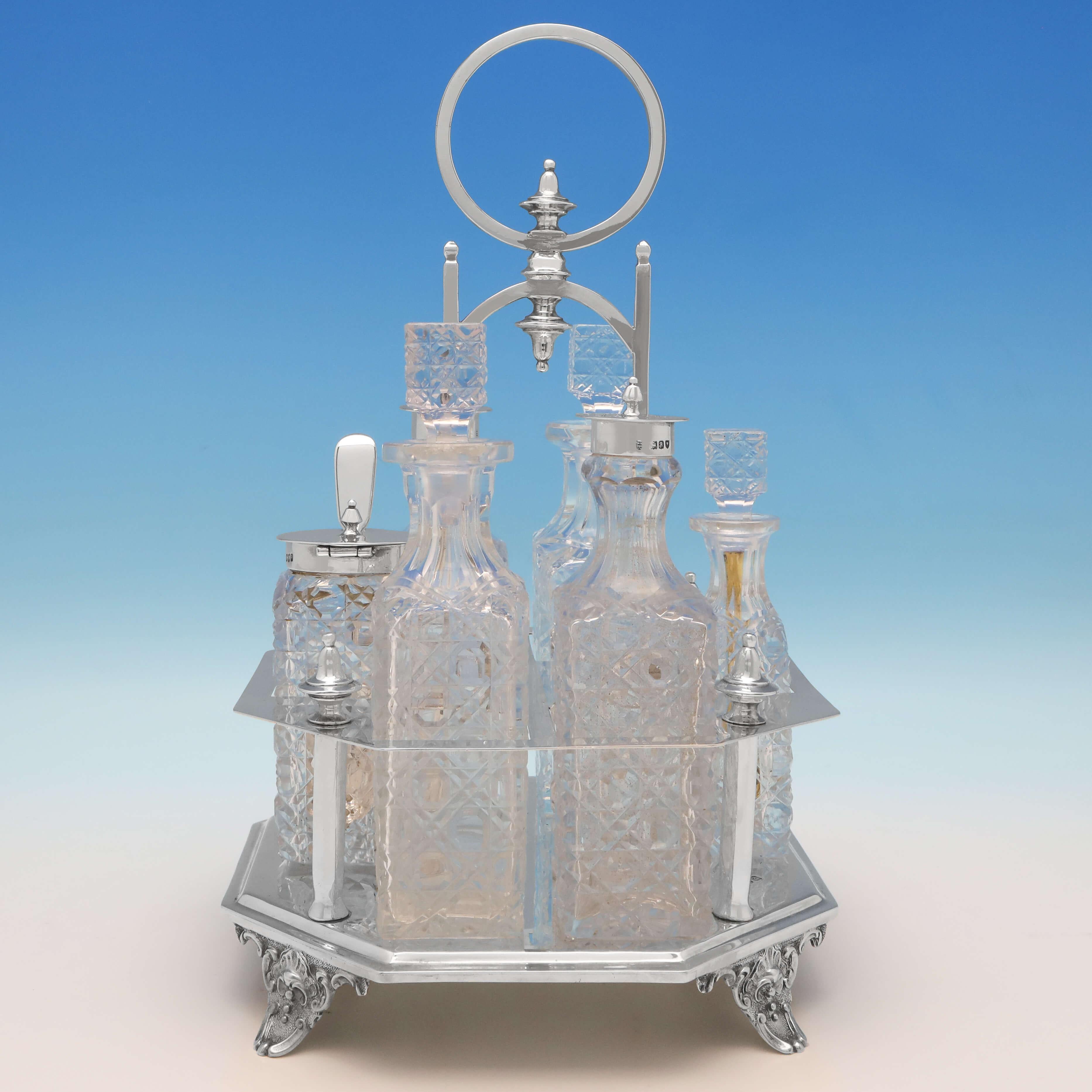 Hallmarked in London in 1896 by Charles Boyton II, this stylish, Victorian, antique sterling silver cruet set, comprises two oil bottles, two pepper pots, a cayenne pepper pot, and a mustard pot, all with hobnail cut glass, and all set in an