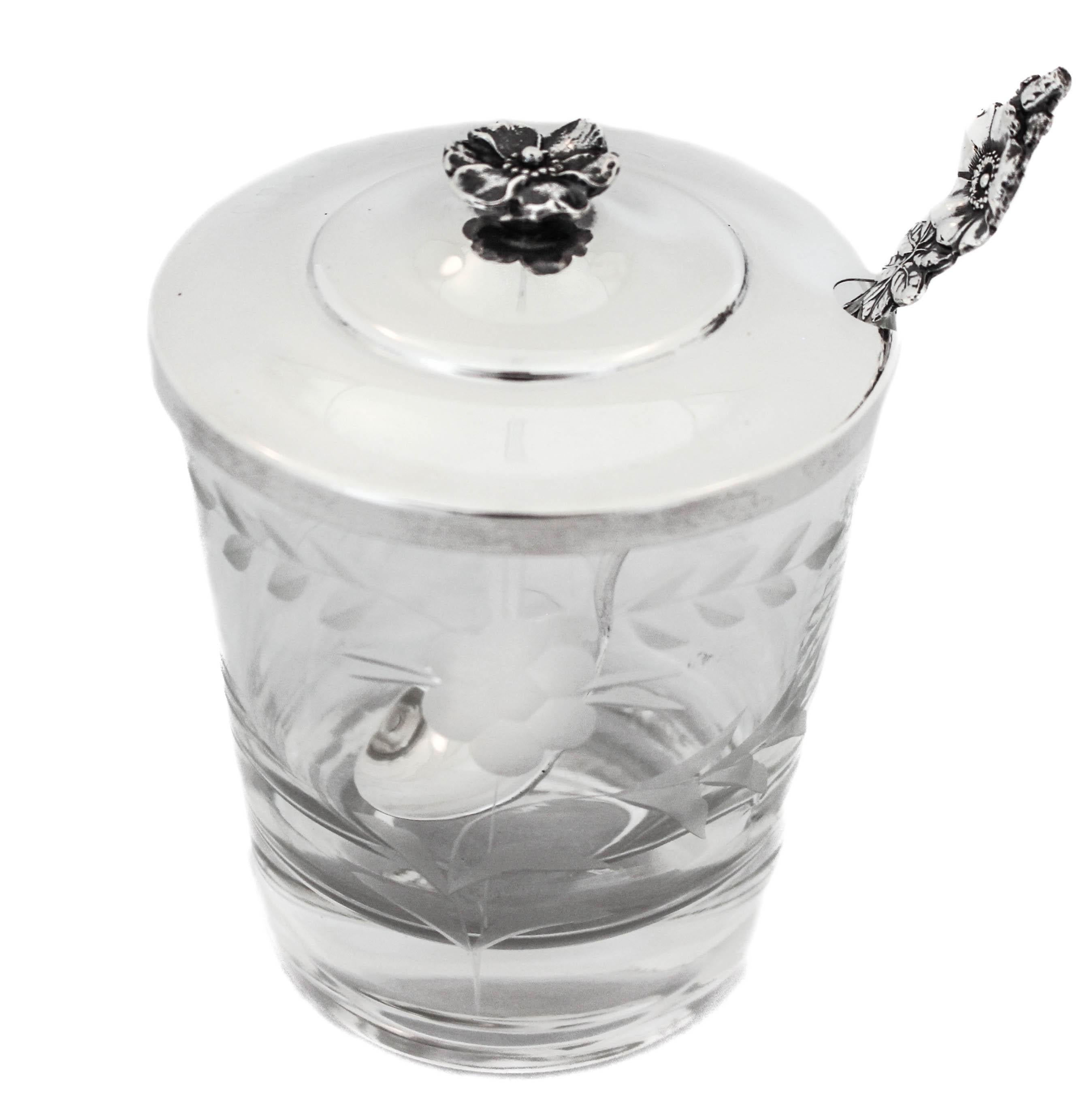 This sterling silver and crystal jar and spoon are made by Reed and Barton. The sterling lid and spoon have the same floral motif while the crystal jar has acid-etched flowers and leaves around the center. The perfect size for jam or any other