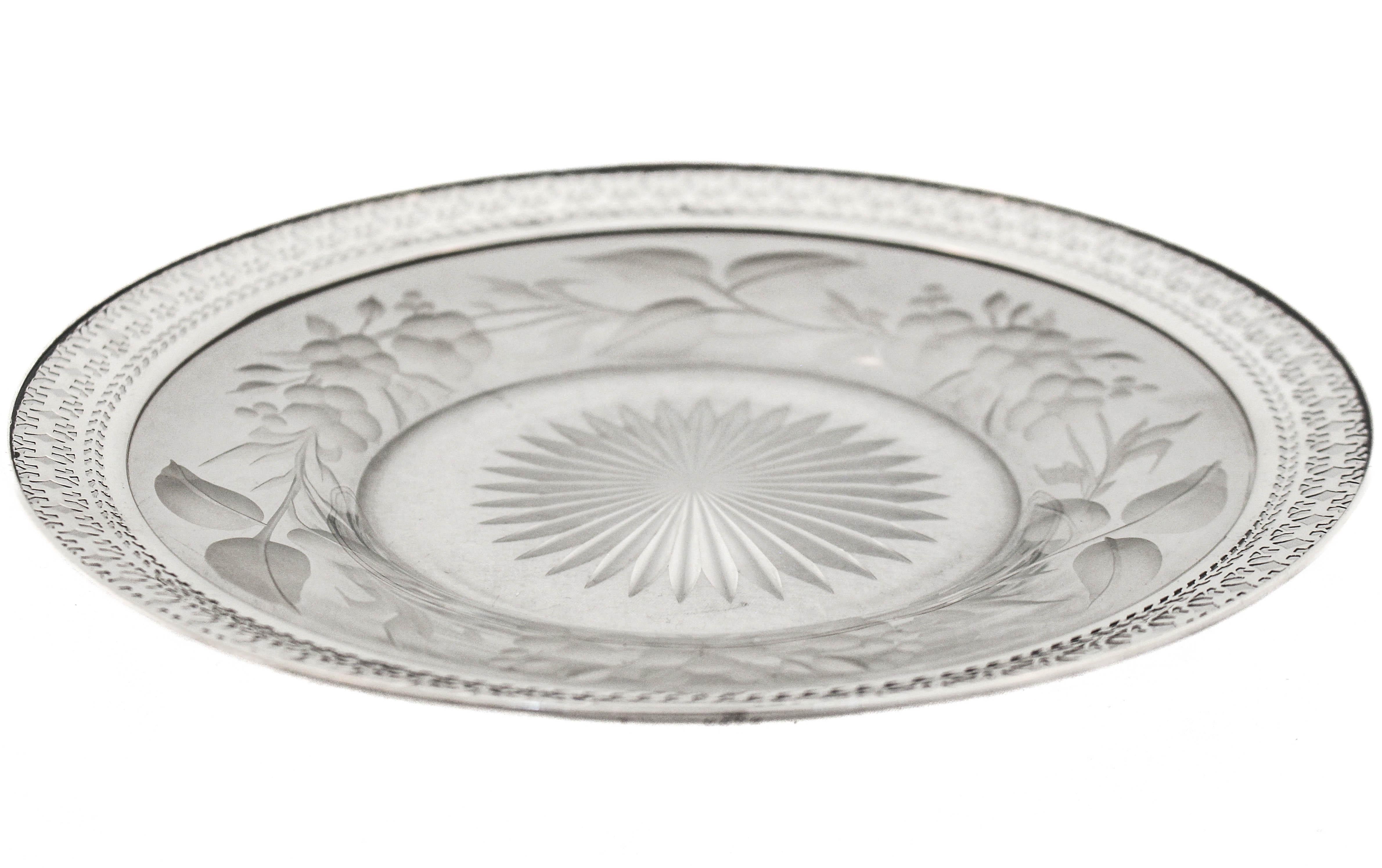 Being offered is a crystal and sterling silver dish by International Silver.  The silver rim is reticulated with an area for a monogram.  The crystal dish has a starburst in the center with an acid-etched floral design going all the way around. 