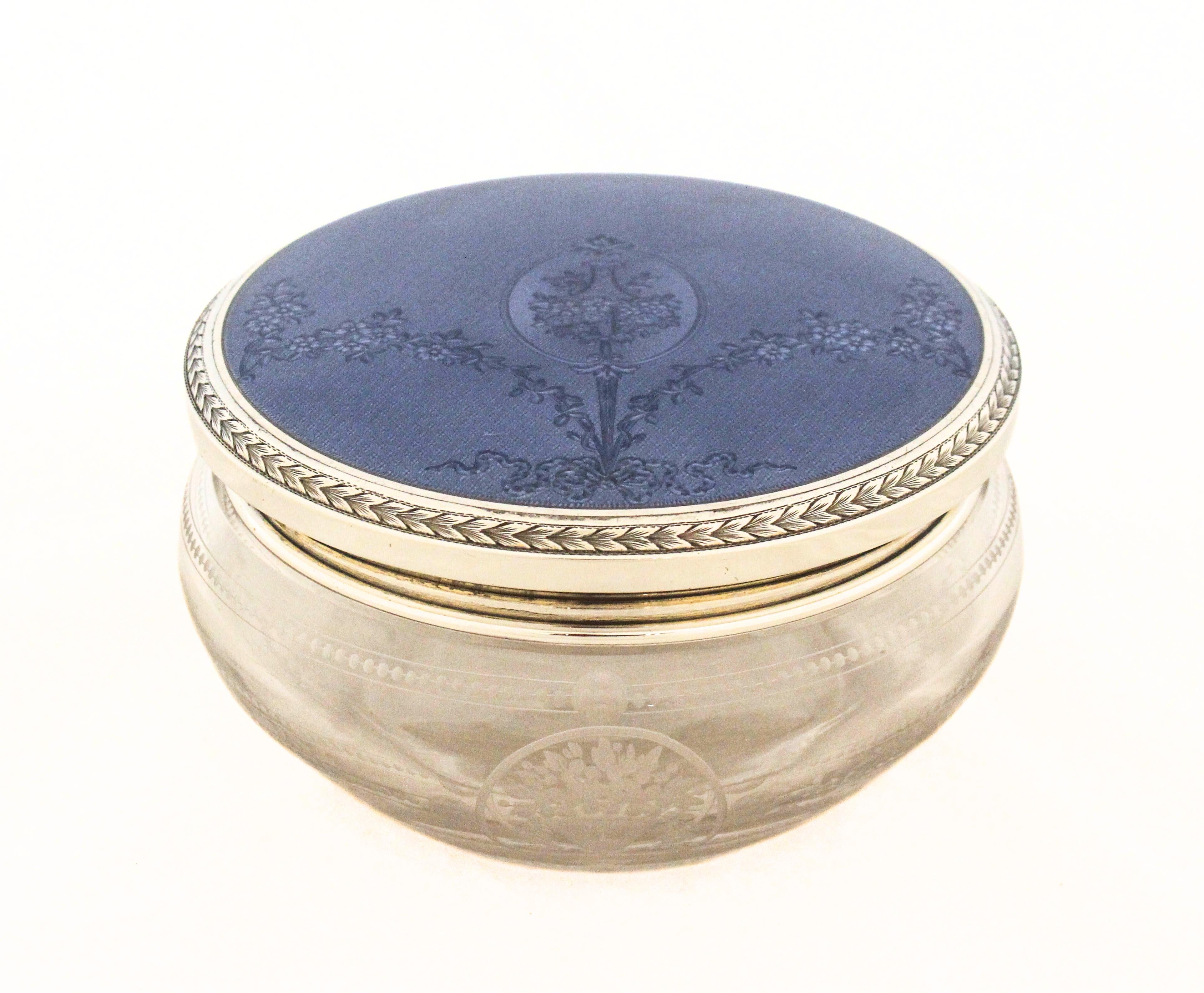 
Coperchio


Il coperchio è realizzato in argento sterling, come conferma il marchio di garanzia impresso.
Presenta una superficie smaltata guilloché di colore blu pallido - uno smalto traslucido posato su un motivo tornito.
La tornitura del motore