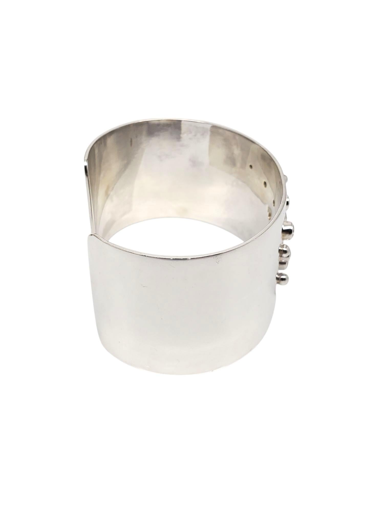 Bracciale largo con cluster di CZ in argento sterling -

Questo bracciale unico presenta 9 pietre CZ incastonate disposte a grappolo in un design in argento sterling lucido.

Dimensioni: 6,75