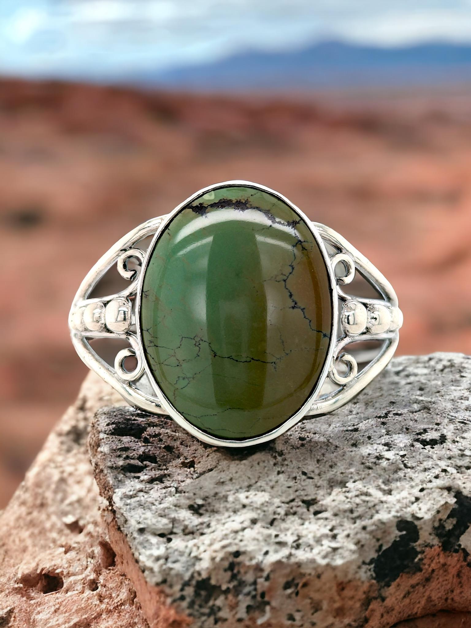 This Bold Green Cuff Bracelet will definitely turn heads. Featuring a captivating green gemstone, this stunning piece is crafted from gleaming Sterling Silver and is ideal for adding a touch of rugged elegance to any outfit.

Unobtrusive Presence: