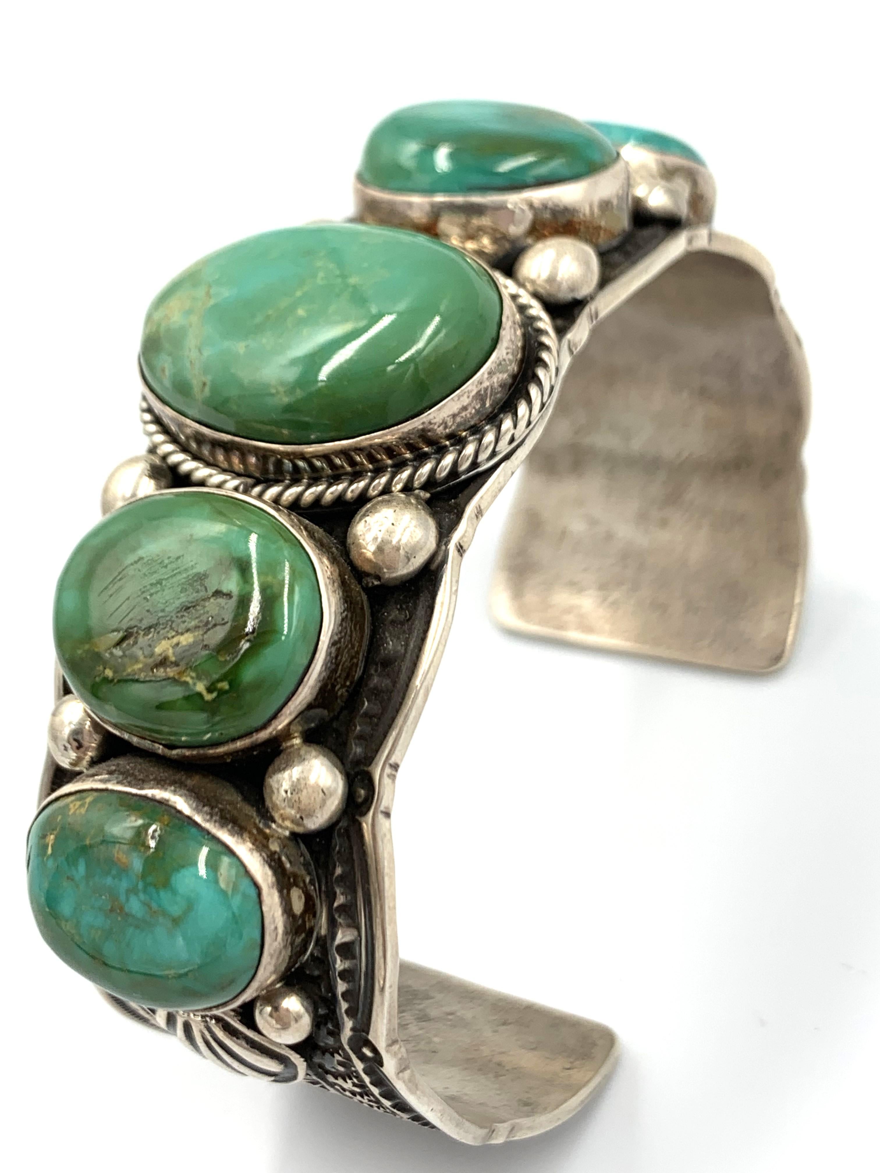 This is a collaborative piece by Guy Hoskie and Bruce Eckhardt. The silverwork was done by Guy Hoskie and the stones were sourced, cut, and polished by Bruce Eckhardt.

The stamped and applique 1” sterling silver cuff has five Blue Gem Turquoise,