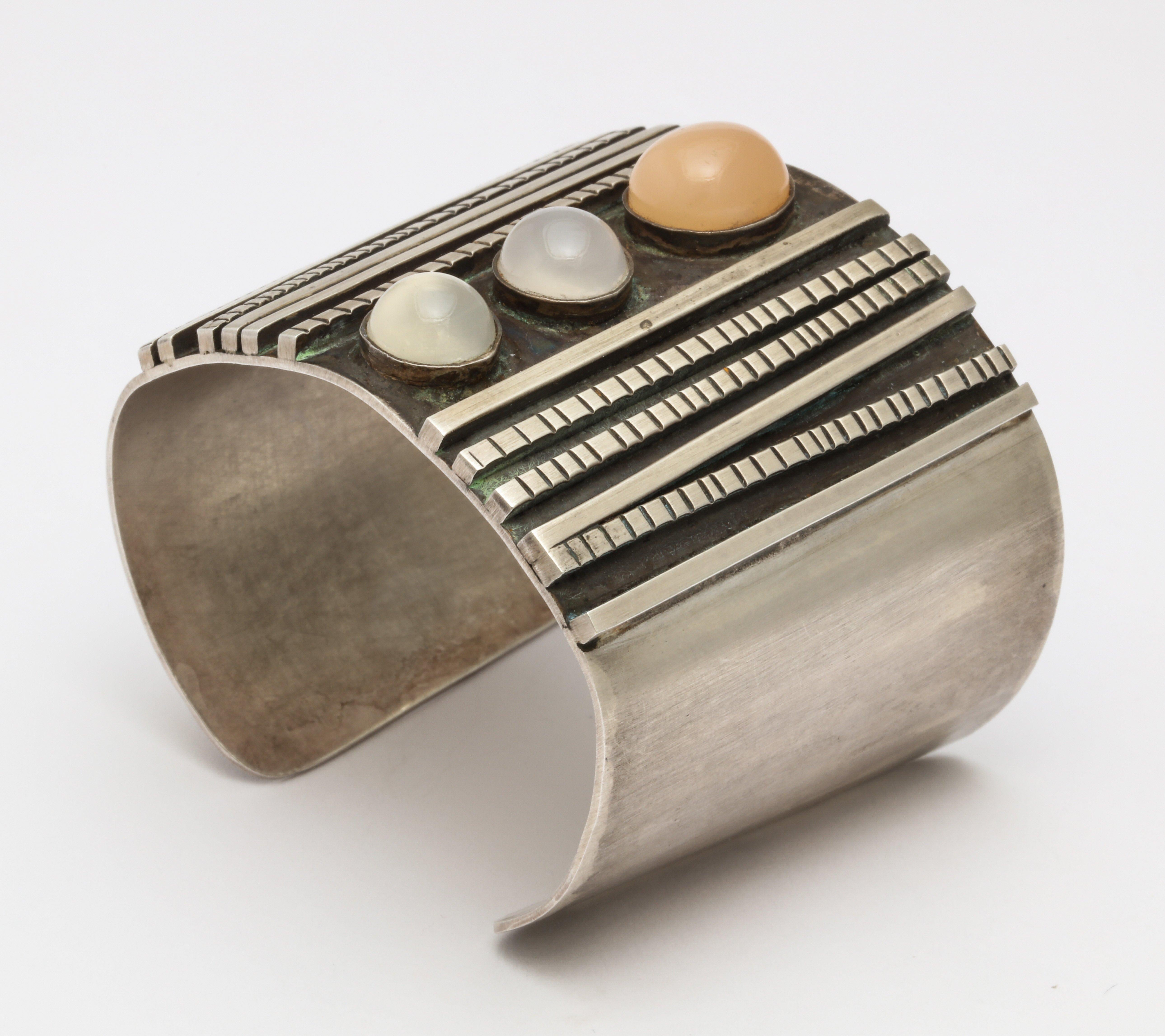 A wonderful sterling silver cuff with cabochons of moonstones inlaid decoration and etched ridges. Marked with sterling and designers mark