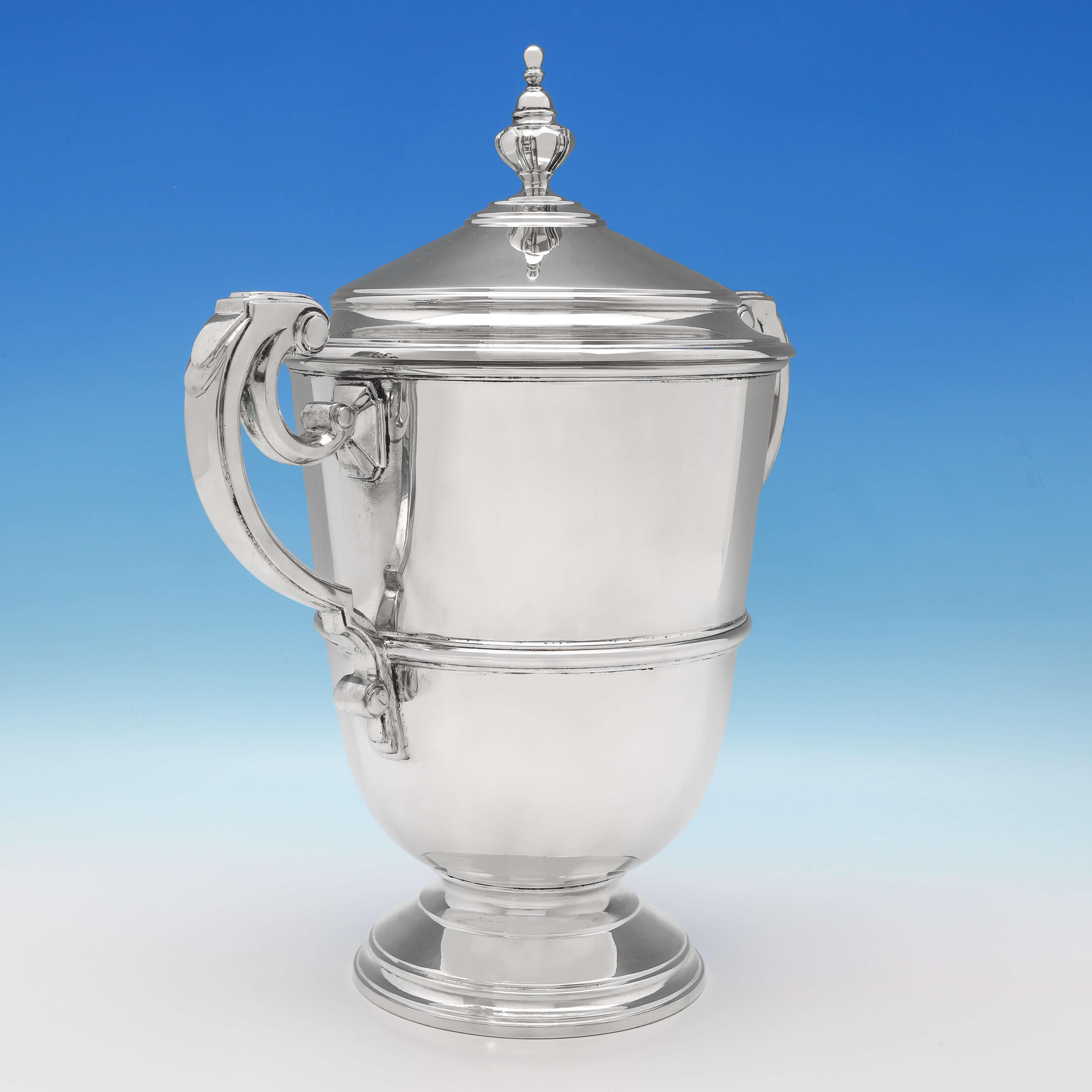 Hallmarked in London in 1934 by Richard Comyns, this exceptional, Art Deco, George V, sterling silver cup and cover, is expertly made, plain in design, and with scroll handles. The cup and cover measures 15