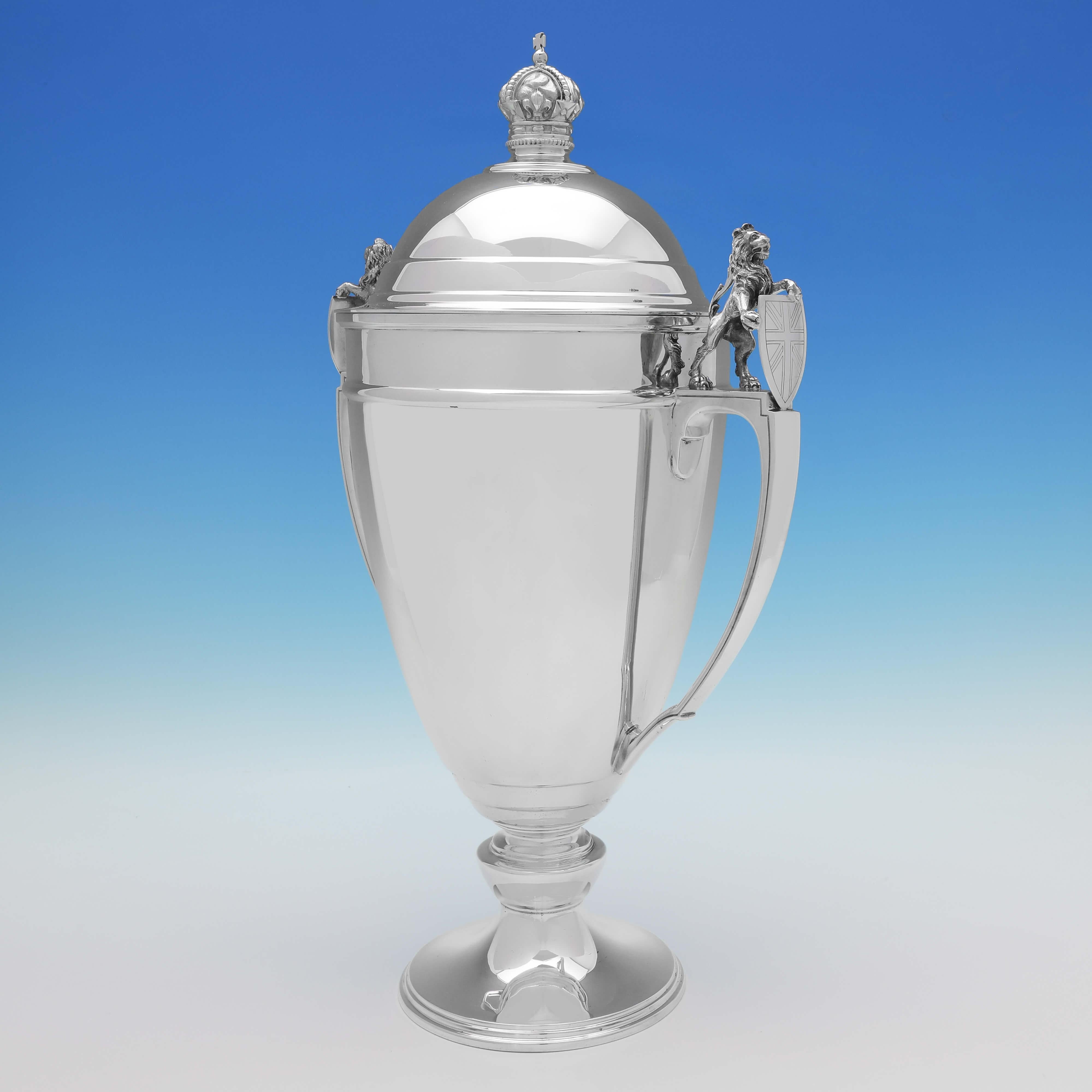 Hallmarked in Sheffield in 1937 by Mappin & Webb, this striking, Sterling Silver Cup & Cover, is in the Art Deco taste, and features models of rampant lions holding shields with the engraved Union Jack to each handle, and a crown finial. The cup &