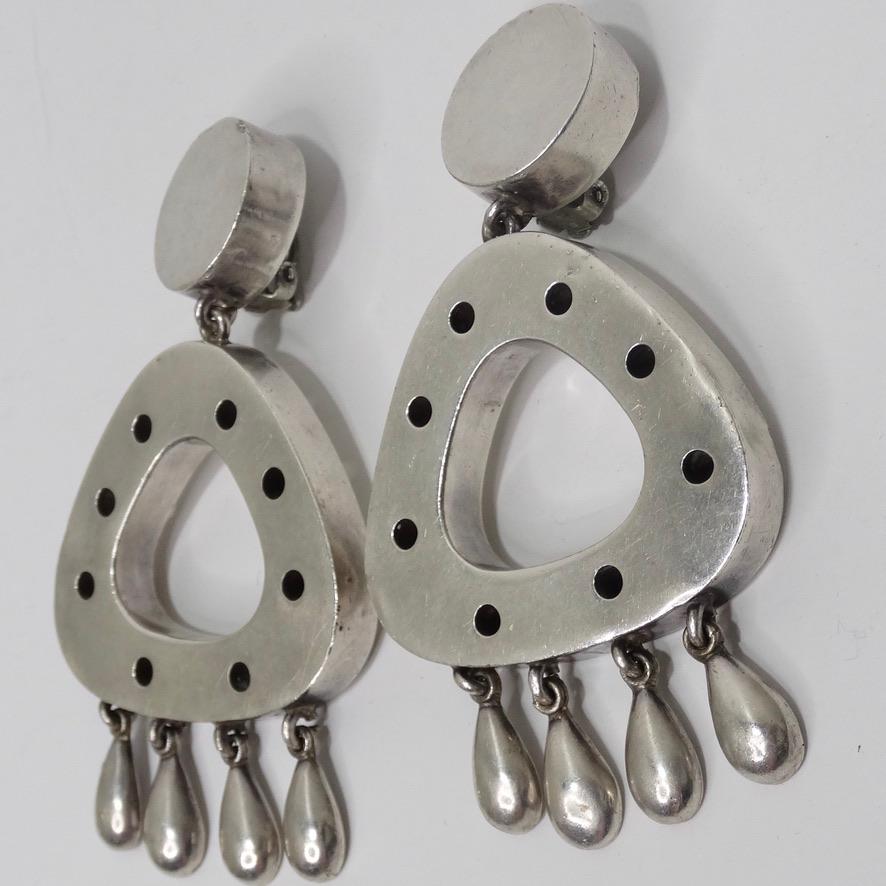 Vintage sterling silver geometric dangle earrings. Solid silver circles accompanied by large triangles with circular cut out motifs are complimented by the tear drops dangling as the finishing touch. These earrings are such a fun statement piece