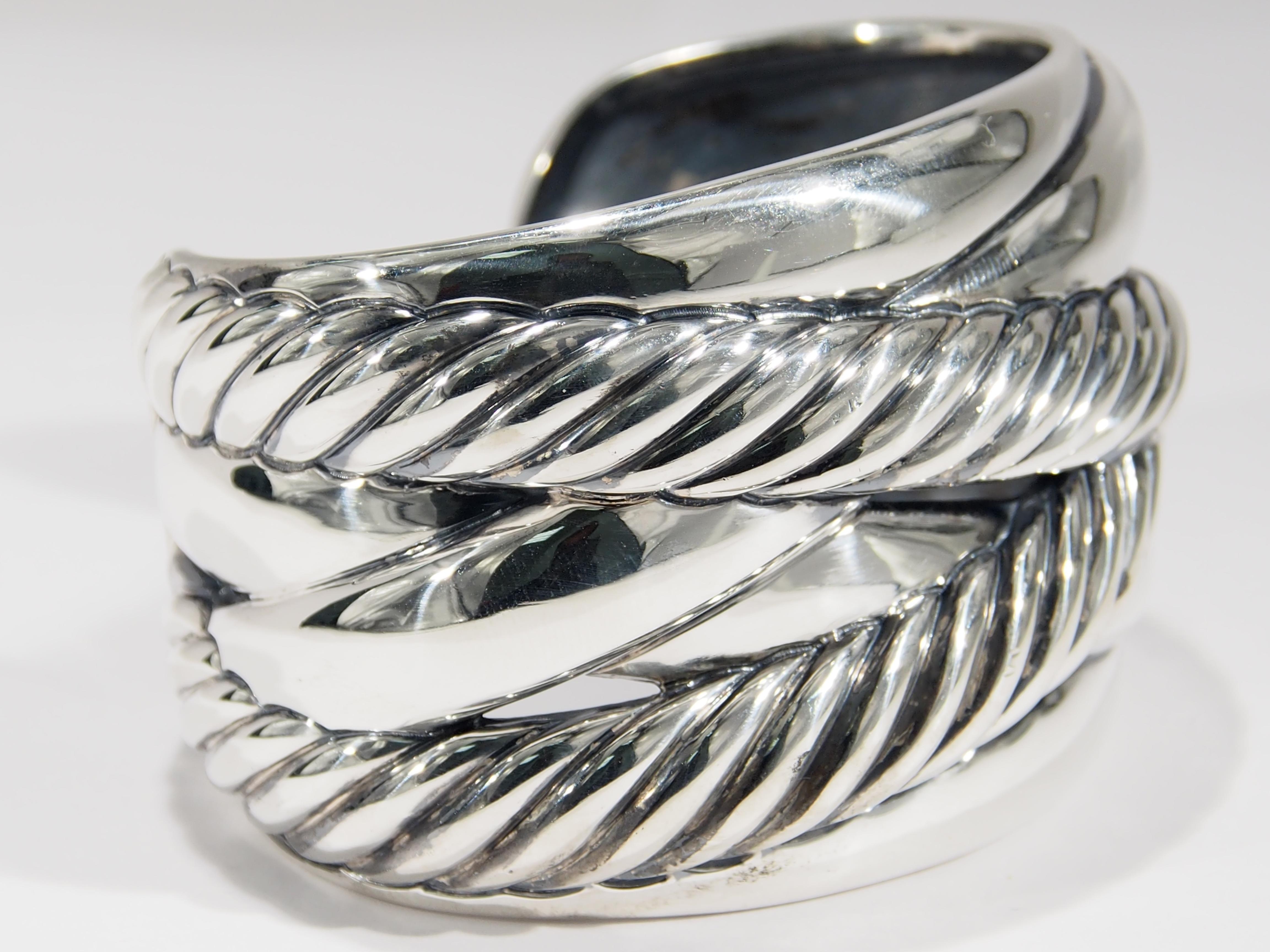 From one of America's favorite jewelry designers, David Yurman is this Sterling Silver Wide Cuff. The Bracelet is 1 3/4 inches in Width featuring cross over rope over smooth bands. Definitely a statement Bracelet to be enjoyed everyday, it measures