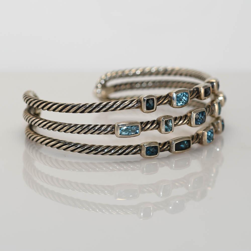 David Yurman blue topaz Confetti, cable style bracelet.
Stamped D.Y. 925 and weighs 32 grams.
There are light blue and dark blue topaz stones with fancy faceting.
The bracelet measures 3/4 inches wide.
The bangle with fit up to 6 /1/2 inch wrists