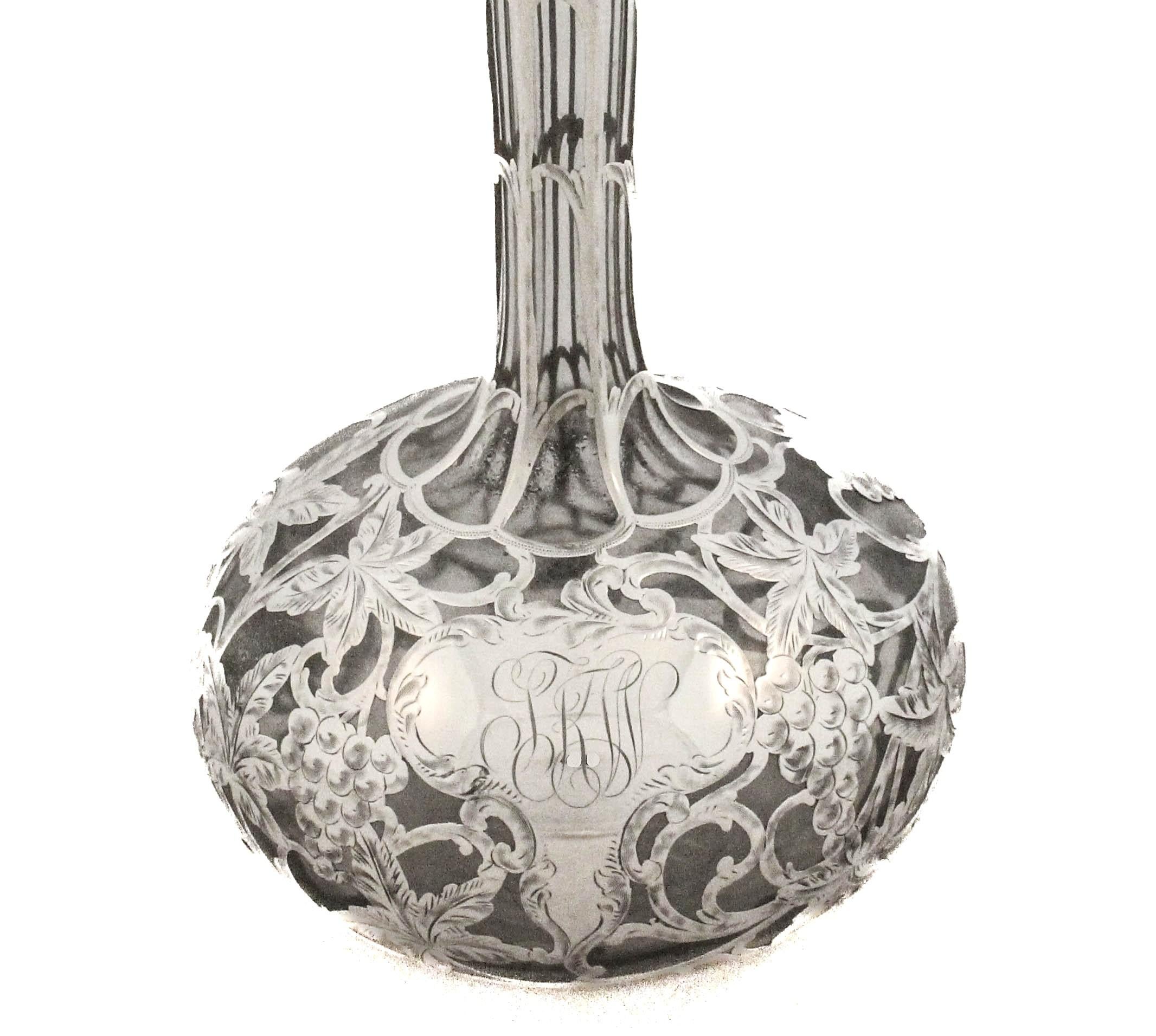 In offerta c'è un elegante decanter di proprietà con una squisita sovrapposizione di argento sterling in un classico motivo a vite. L'intricato design mostra dettagliati grappoli d'uva intrecciati a tralci di vite e foglie finemente incise, che