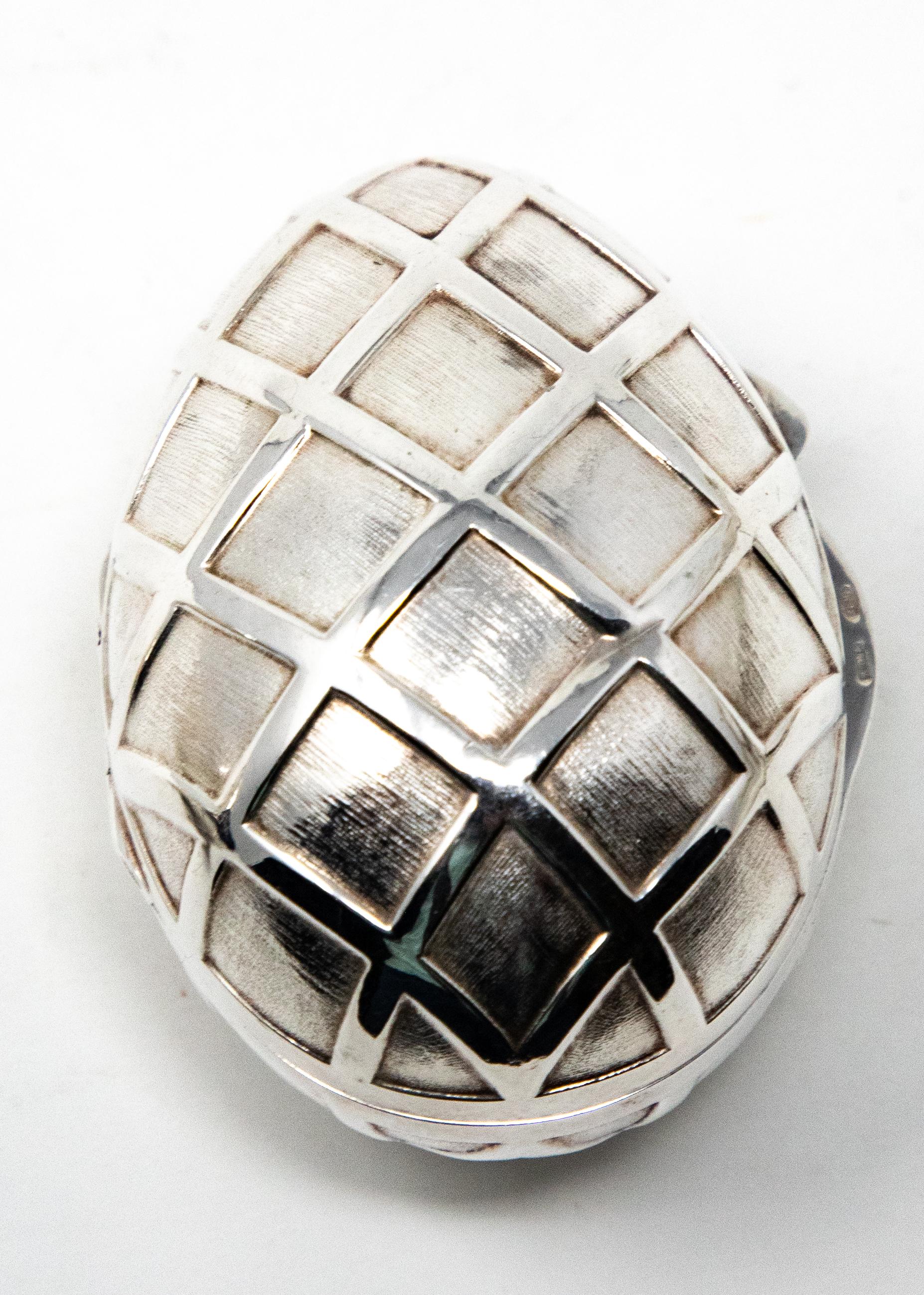 Offering this stunning sterling silver decorative egg. This egg is done in a geometric diamond pattern all-over the body. It is hinged and does open and has a latch. The inside you can see the diamond pattern reversed. It is marked 925, and sterling