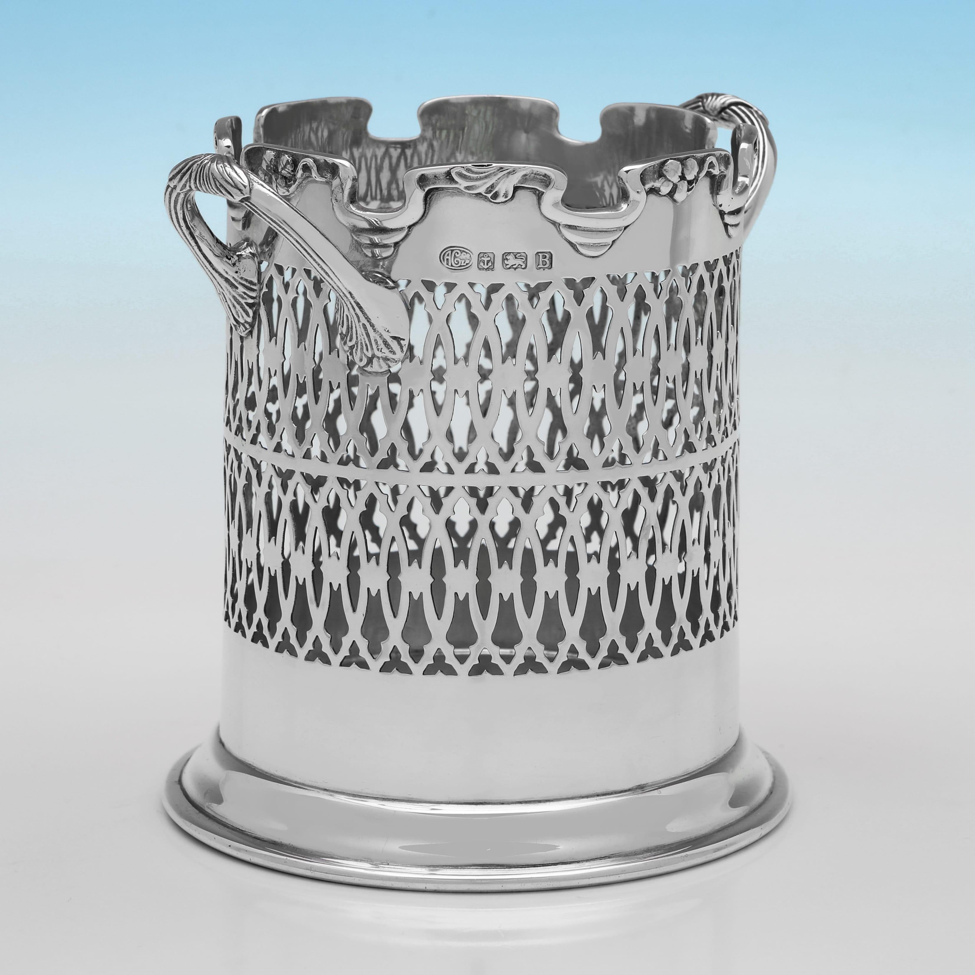 Sellado en Birmingham en 1926 por Alexander Clark & Co. Ltd., este hermoso sifón de plata de ley de la época de Jorge V presenta decoración perforada en los laterales, asas con detalles de conchas y un borde perfilado. El soporte del sifón mide 14,5