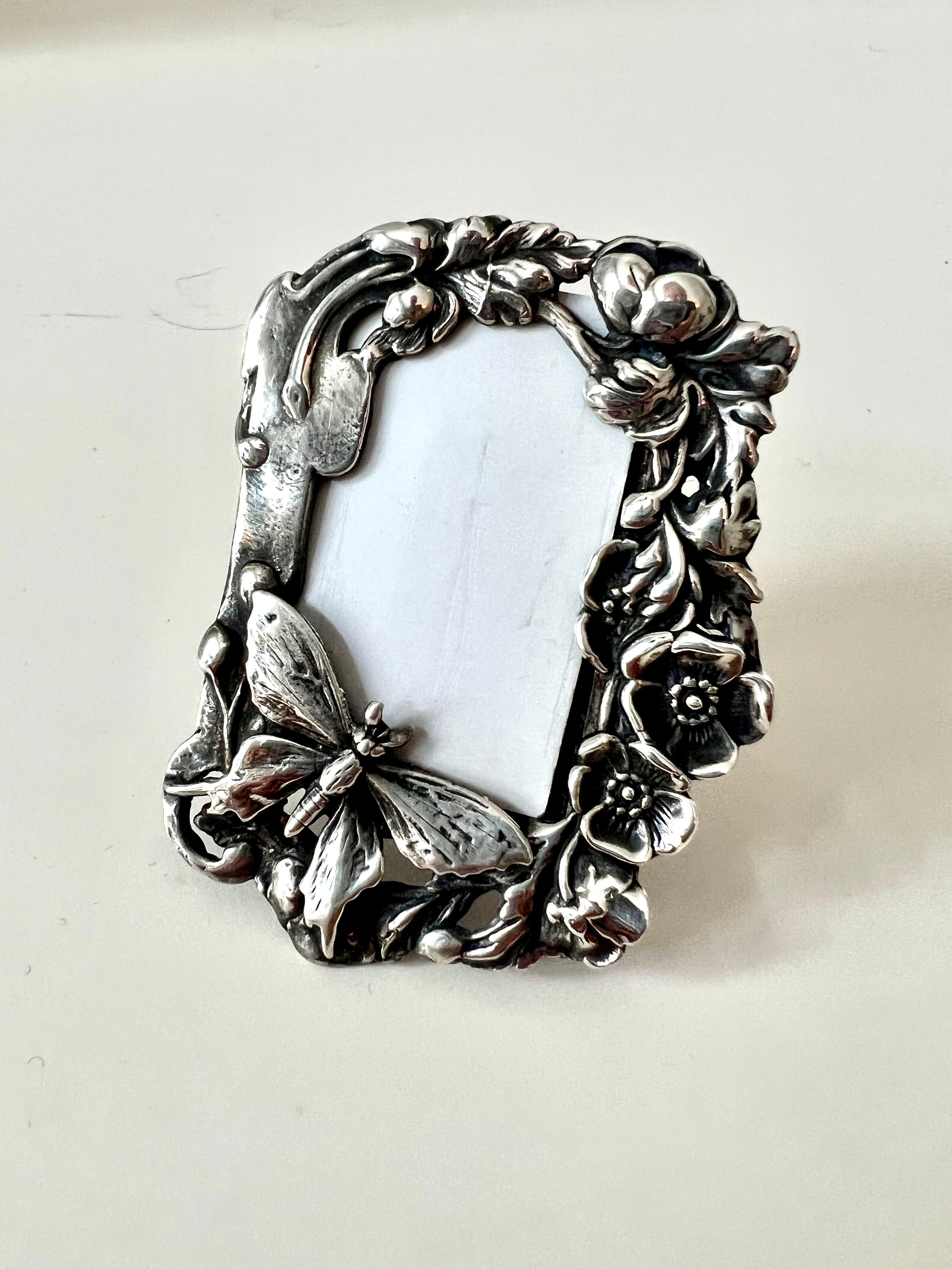 A beautiful small sterling picture frame with flowers, and butterfly - the frame is ideal for bedside, a desk, or special collection of mementos.  

We also think it's the perfect frame to carry your loved one in while traveling.

A great wedding