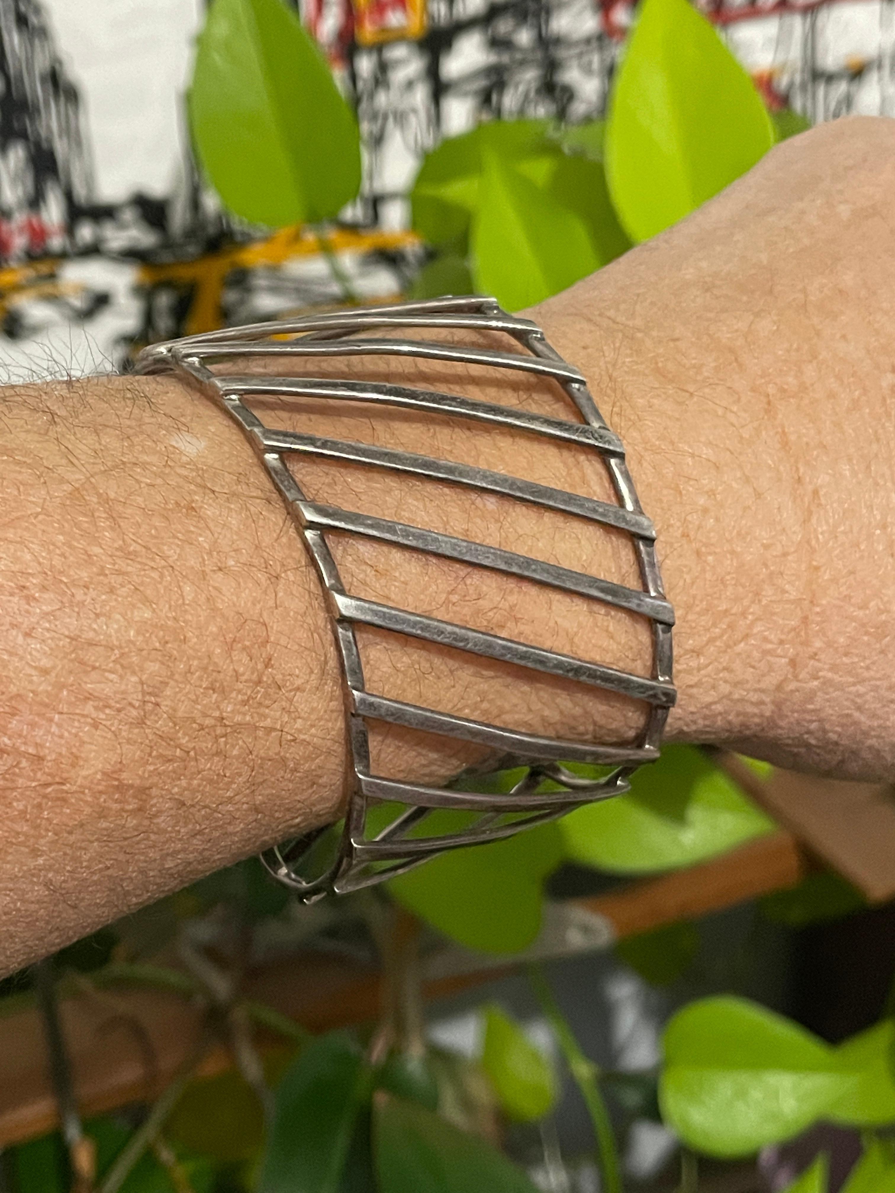 Grand travail diagonal ouvert sur ce bracelet moderniste. Peut être ajusté en plus ou en moins. Elle est présentée sur un poignet de 6,5 pouces sur les photos. Le poinçon est apposé à l'intérieur du bracelet. N'hésitez pas à consulter notre vitrine