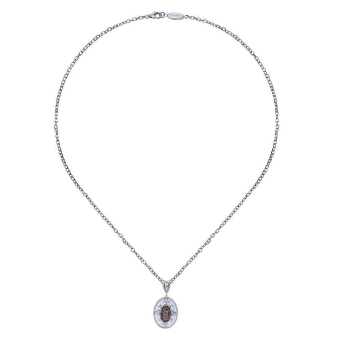 Sterling Silver, Diamonds and Smoky Topaz Pendant. Elegant oval design with filigree brings the eye to a pave set center of cappuccino colored smoky topaz and diamond accents. Pendant contains 0.12 ctw of round white diamonds, and 1.87 carats of
