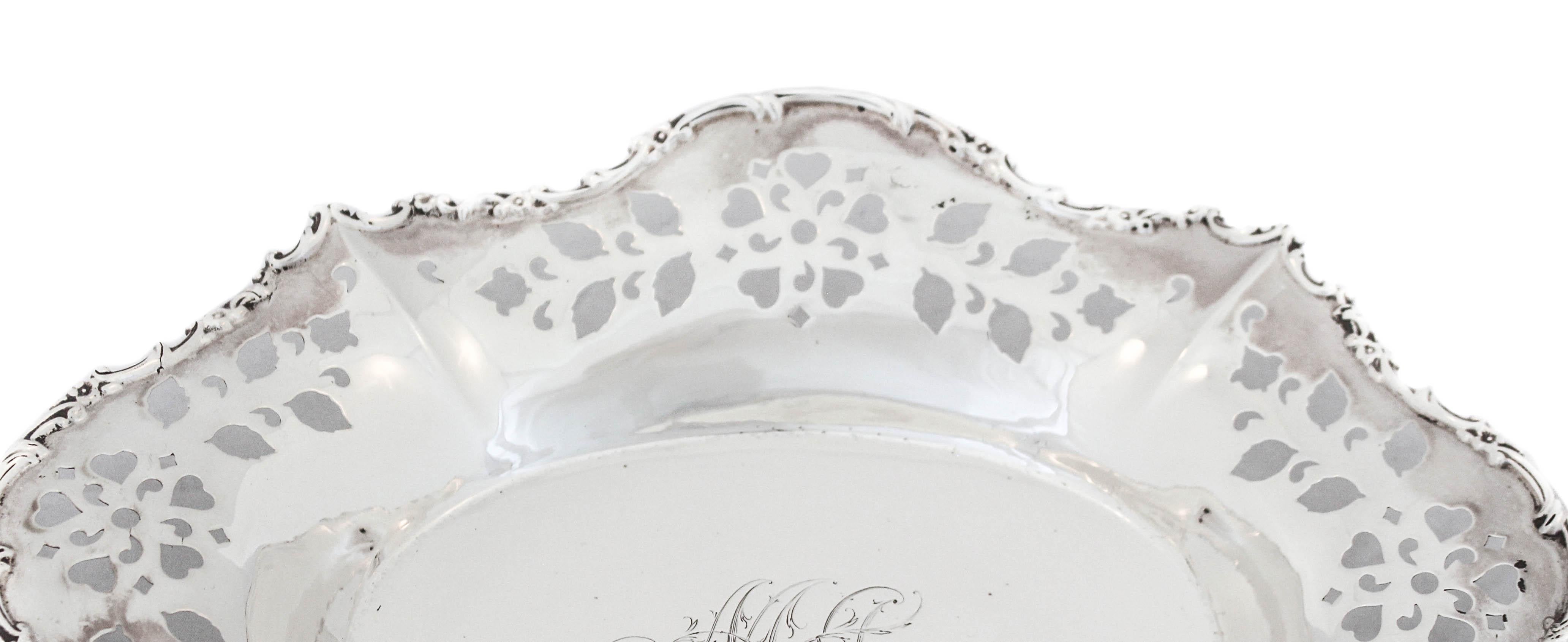 Being offered is a sterling silver oval dish by Wilcox and Evertsen of New York. The edge is scalloped with a decorative rim and along the sides there is a reticulated pattern of hearts and leaves. In the center there is a hand engraved script