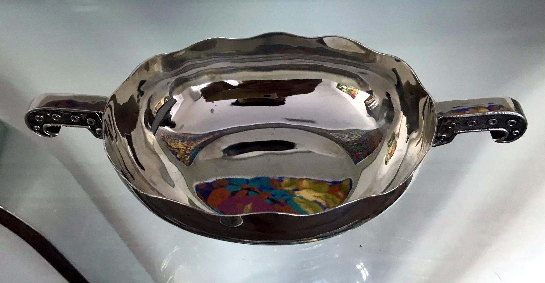 Modern sterling silver footed dish with handles designed and crafted by Tane Orfebres in Mexico. The open dish is decorated with features of the mythical Quetzalcoatl design on the handle and around the base.
Hallmarked to the bottom rim as shown.