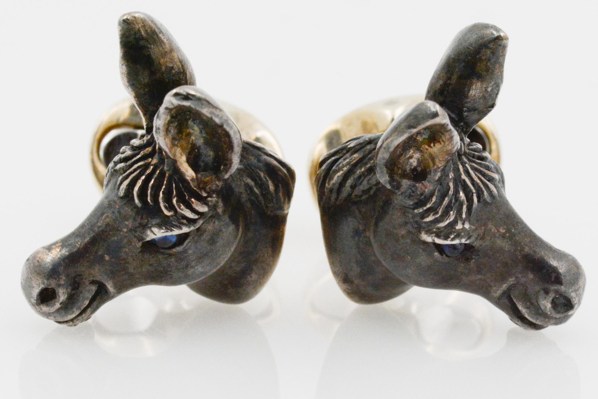 Ces boutons de manchette en sterling ont un design de tête d'âne réaliste, avec des détails complexes des oreilles, de la crinière et des yeux bleu saphir. Ces boutons de manchette ont un dos ovale. 

