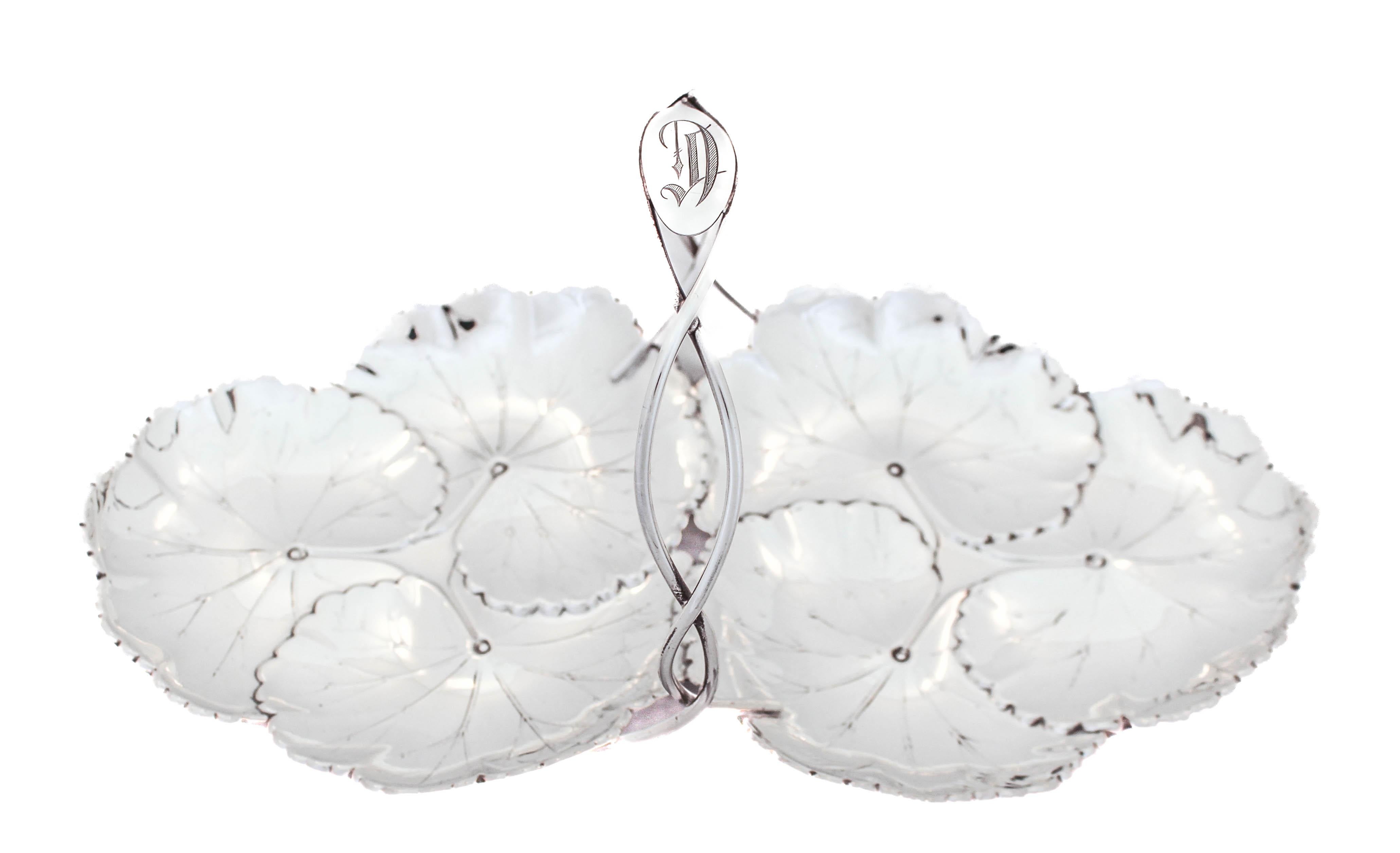 Being offered is a sterling silver double-dish with a handle.  This piece is manufactured by Reed & Barton and hallmarked 1941.  It has an Art Nouveau design with its scalloped rim and water lilies motif.  The handle in the center has a braided