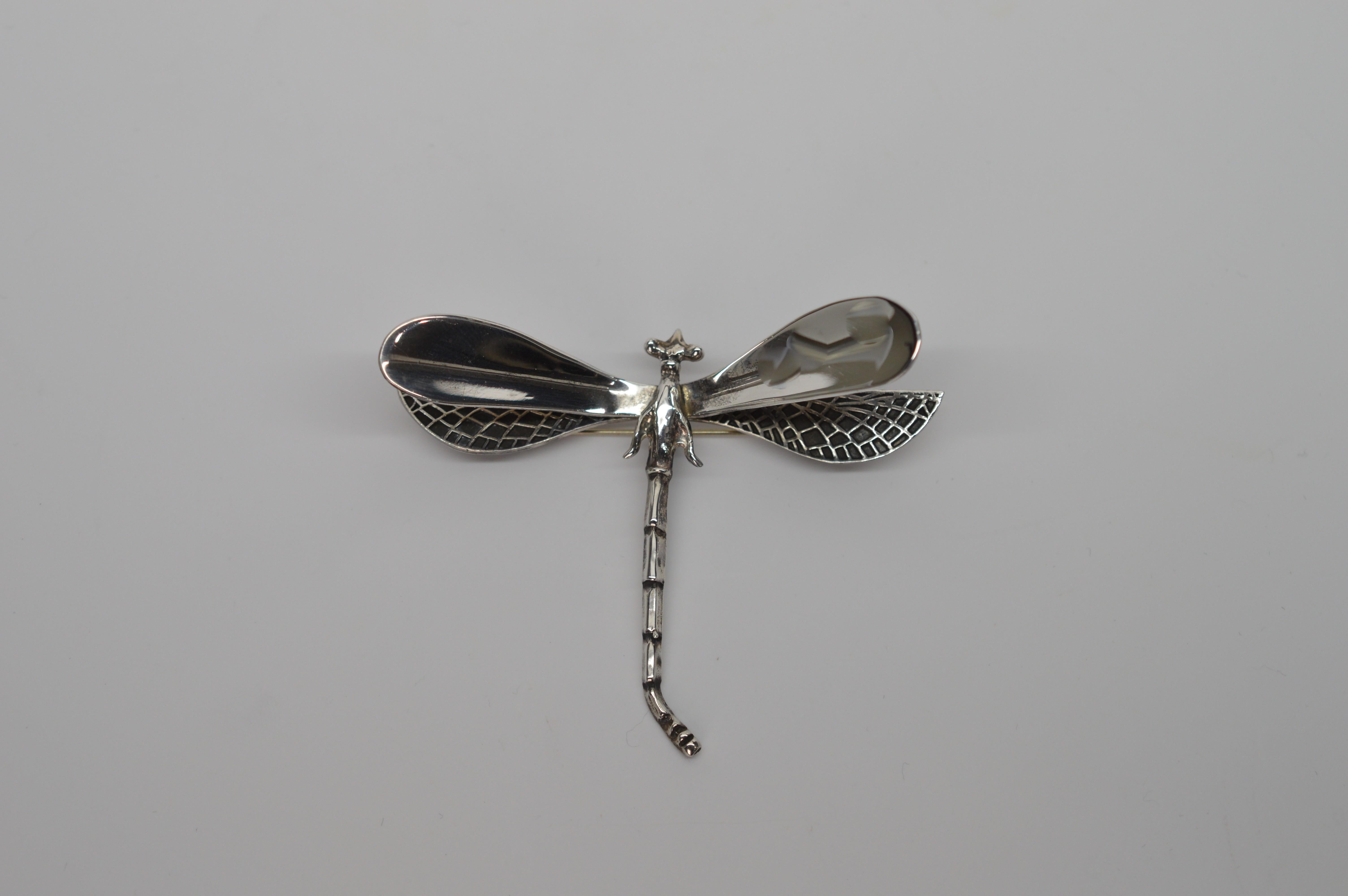 Fun and whimsical, this duo of nature's creatures depicted in Sterling Silver is sure to grab attention.  In an arts and crafts style, the Dragonfly Pin Brooch is multi-dimensional and has a 3 inch wing span and 2-1/4 inch body length. The