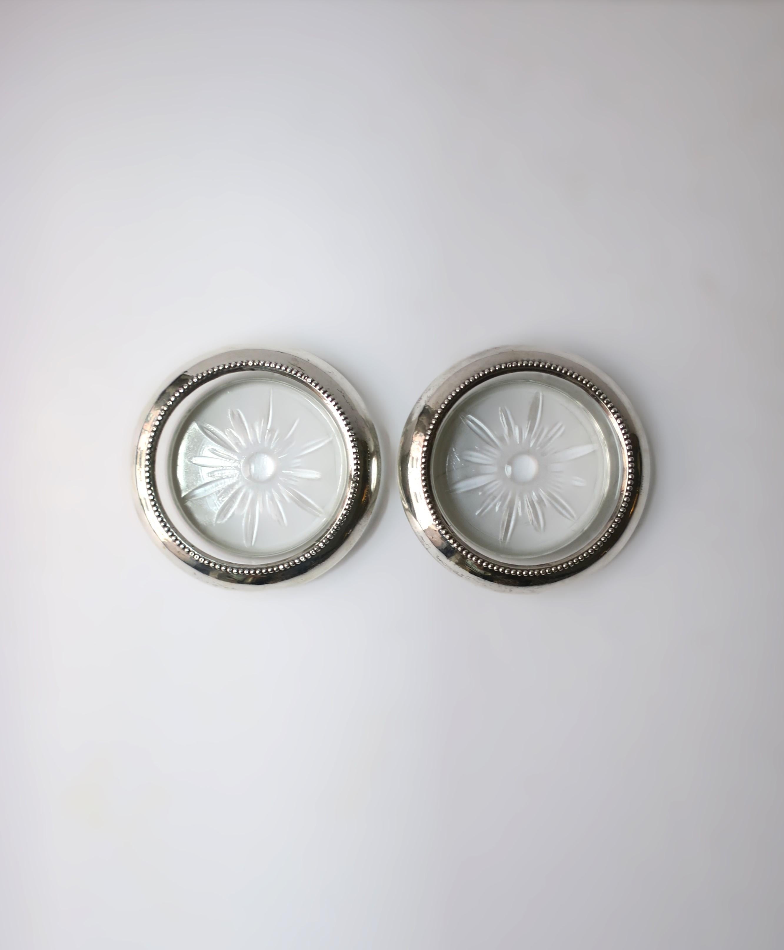 Ein Paar von zwei (2) Getränkeuntersetzern aus Sterlingsilber und Glas, circa frühes 20. Jahrhundert. Untersetzer aus Sterlingsilber mit kleinen Perlendetails, auf einem Glassockel mit Starburst-Design. Unverzichtbar für den Schutz von
