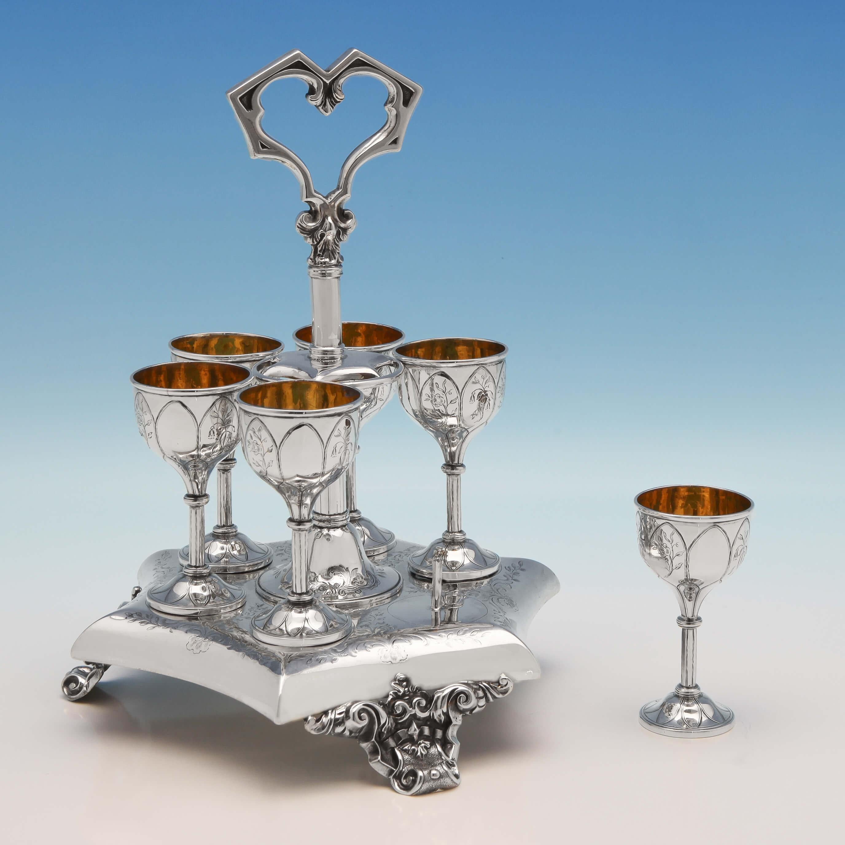 Hallmarked in London in 1845 by Joseph Angell & Son, this elegant Antique, Victorian, Sterling Silver Egg Cruet is in the Gothic Revival Style. The six gilt egg cups stand on an hexagonal star point frame with floral engraving throughout. The frame,