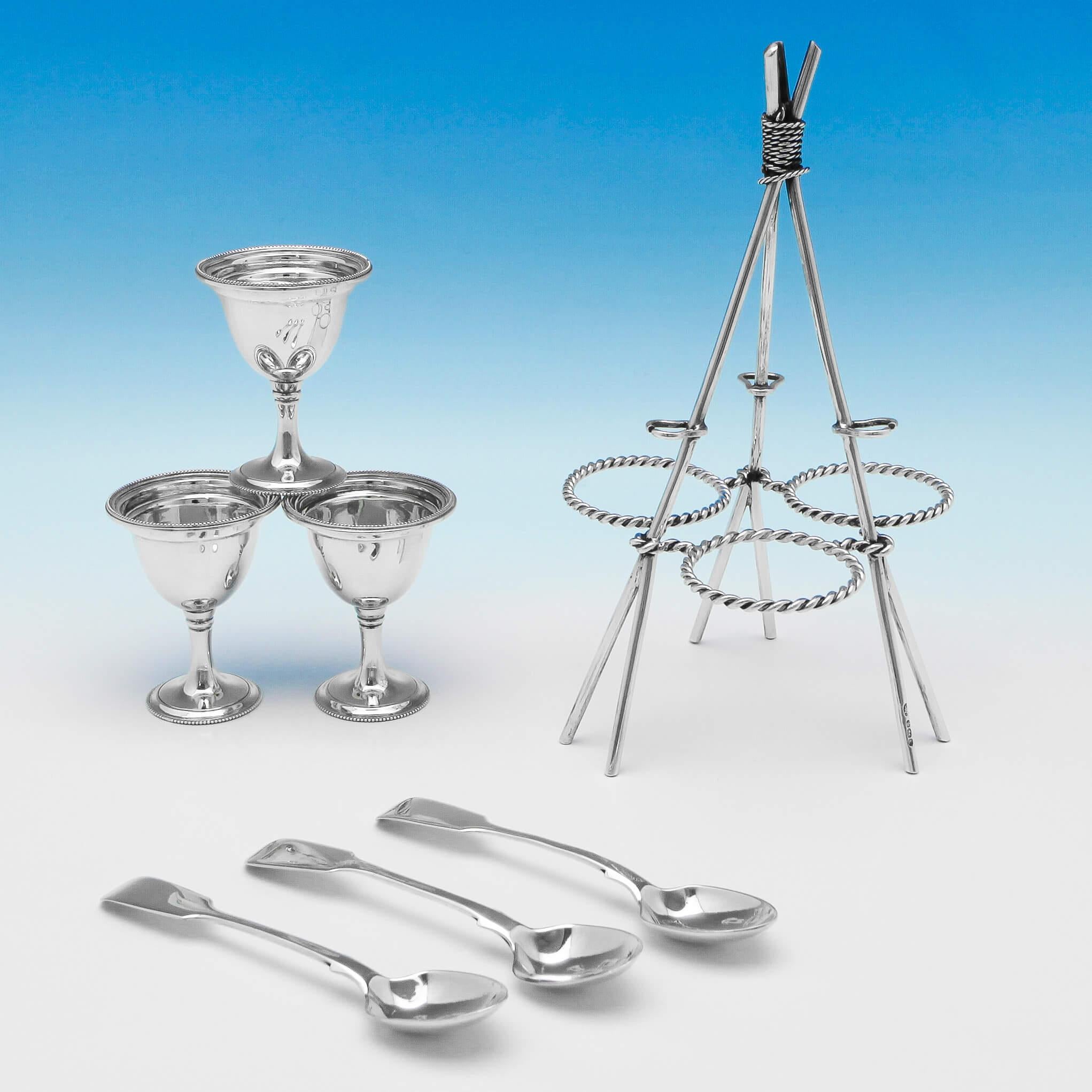 Hallmarked in Sheffield in 1894 by John Round & Son Ltd., this novelty, Victorian, antique sterling silver egg cruet, takes the form of a lashed cooking tripod, with a silver rope fastening the egg cups in place and a spoon attached to each leg. The
