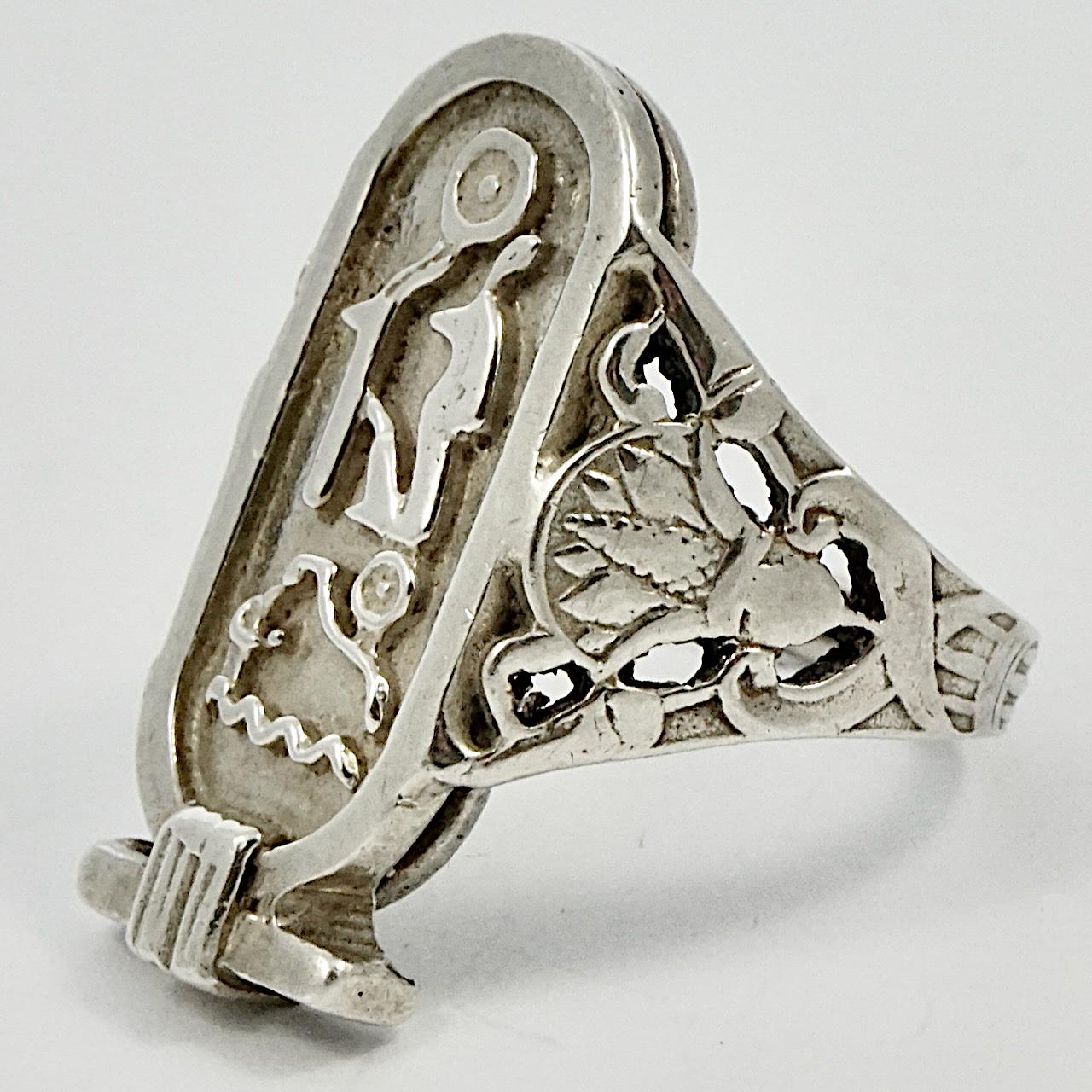 Wonderful sterling silver Egyptian Revival pharaonic cartouche ring with hieroglyphics. The shoulders have a lovely lotus flower decoration. Ring size UK P 1/2, US 7 3/4, inside diameter 1.8 cm / .7 inch, and length at the front 2.6 cm / 1 inch by