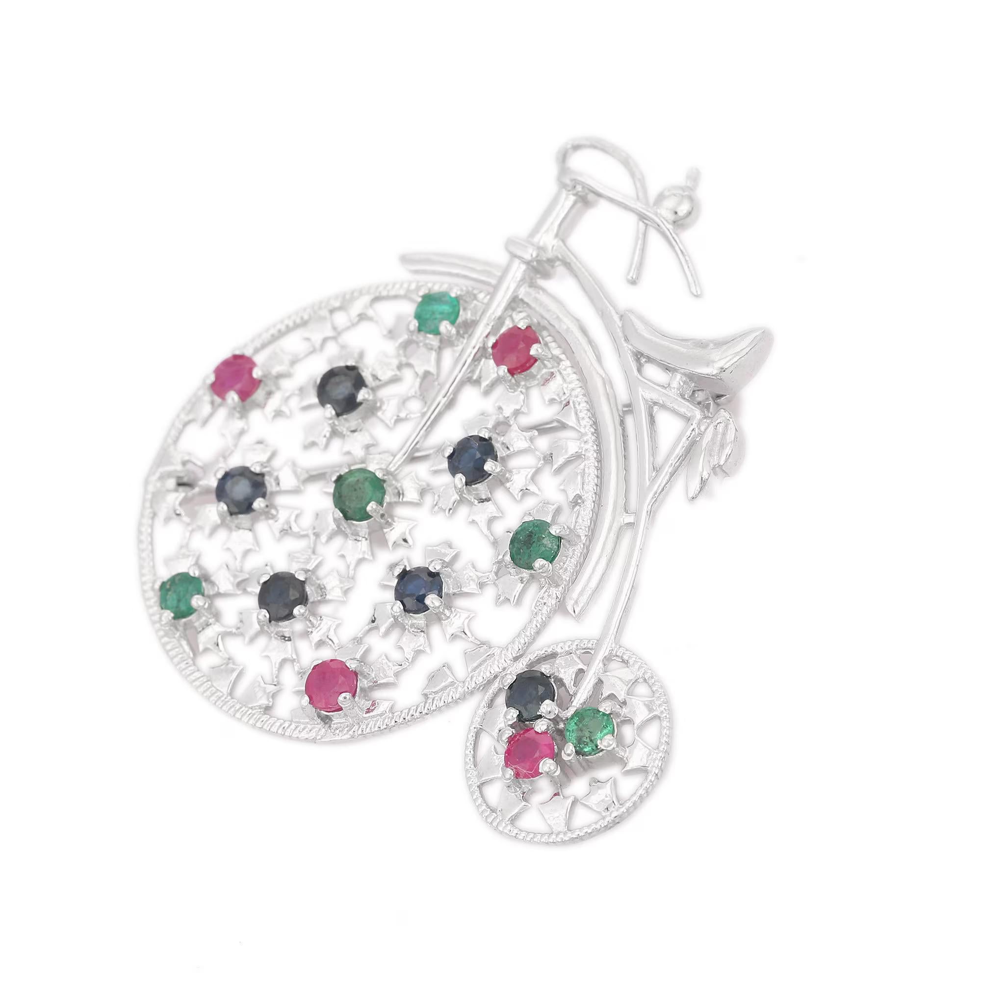 This Emerald Ruby Sapphire Multi Gemstone Bicycle Brooch enhances your attire and is perfect for adding a touch of elegance and charm to any outfit. Crafted with exquisite craftsmanship and adorned with dazzling emerald, ruby and sapphire where ruby