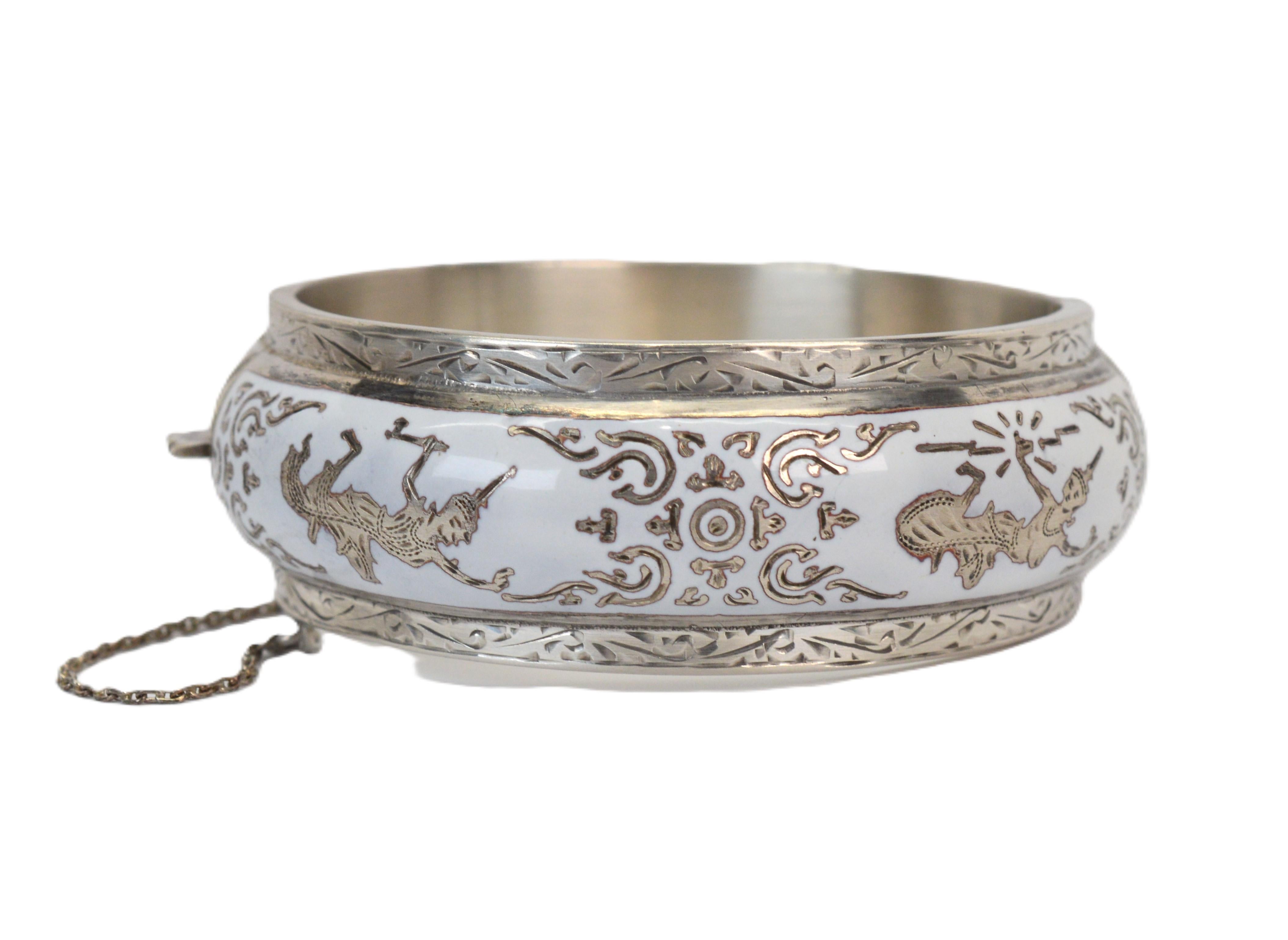 In argento sterling, stravaganti ballerine del tempio saltellano lungo la circonferenza di questo braccialetto bangle vintage. A impreziosire l'intricato design c'è lo smalto bianco applicato a mano, che ne esalta le caratteristiche artigianali.
Un