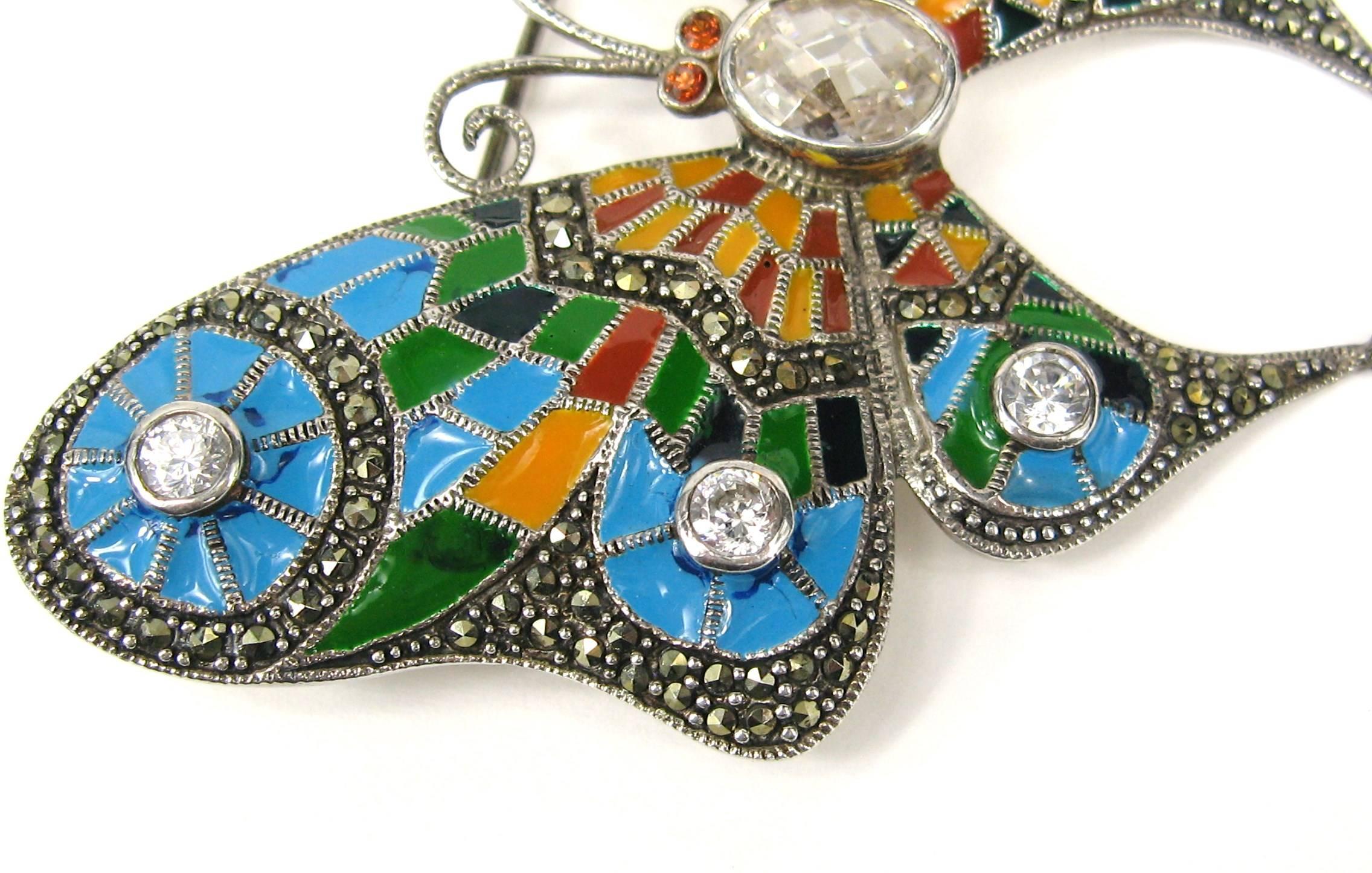 Stunning Sterling Silver Enameled Butterfly Brooch. Colors are Oranges, Blues and greens with a bit of black. This Measures 2.85 in x 2.44 in wide. Marcasites scattered throughout the Brooch and a large faceted crystal in the center. Bezel set