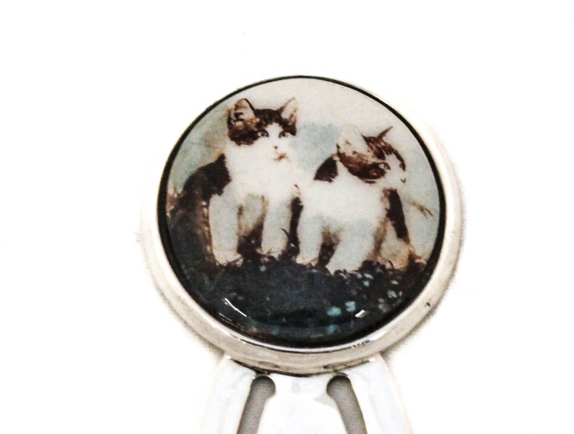 Due gatti in smalto sovrastano questo segnalibro in argento sterling.  I gatti sono adorabili e coccolosi e quale modo migliore per dimostrare il tuo amore per queste maestose creature se non vederli ogni volta che apri o chiudi un libro? Un