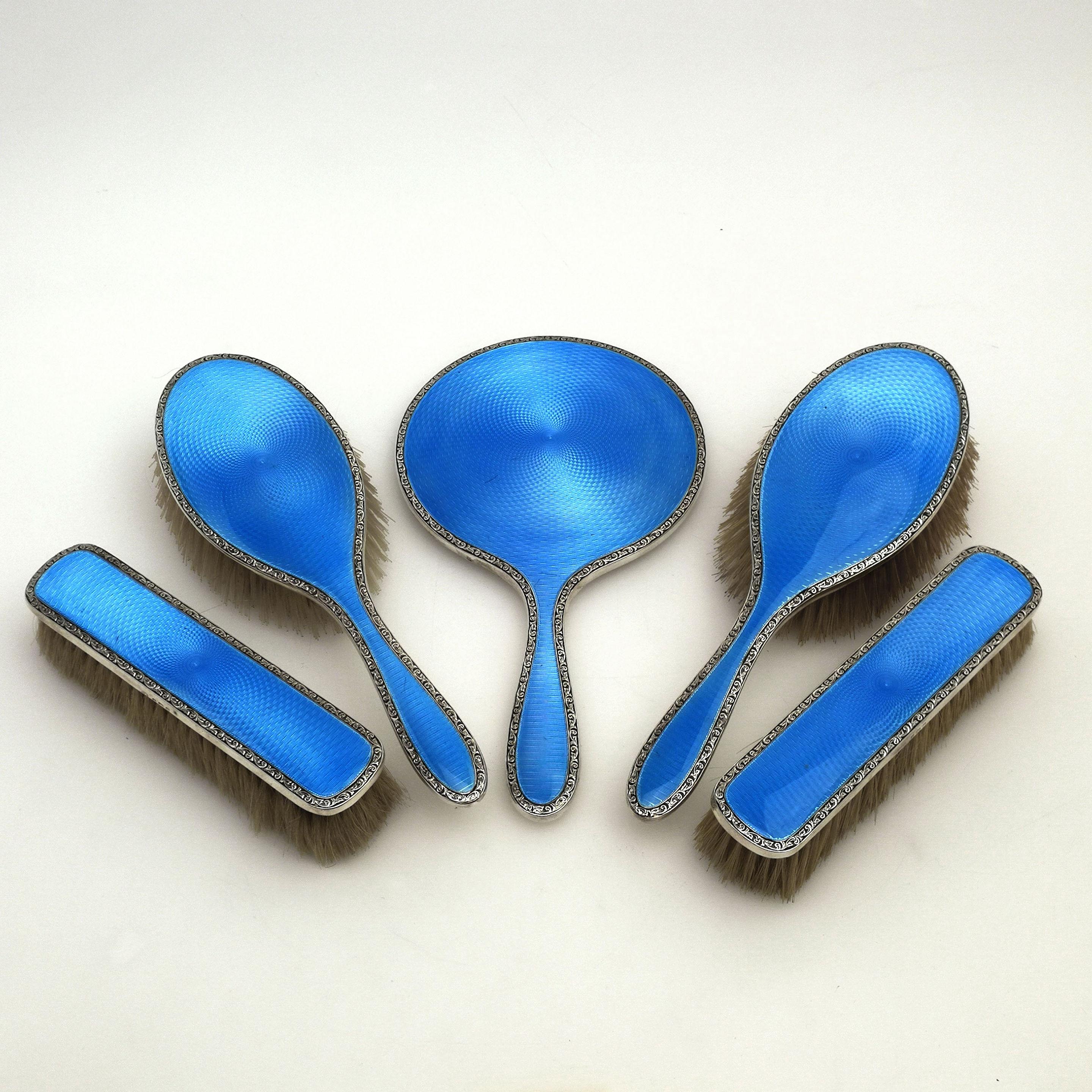 A gorgeous vintage sterling Silver & Enamel Dressing Set. Each piece in this Dressing Table Set is created in solid Silver and embellished with a rich blue guilloche enamel design. The Vanity Set comprises of a hand mirror, a pair of hair brushes, a