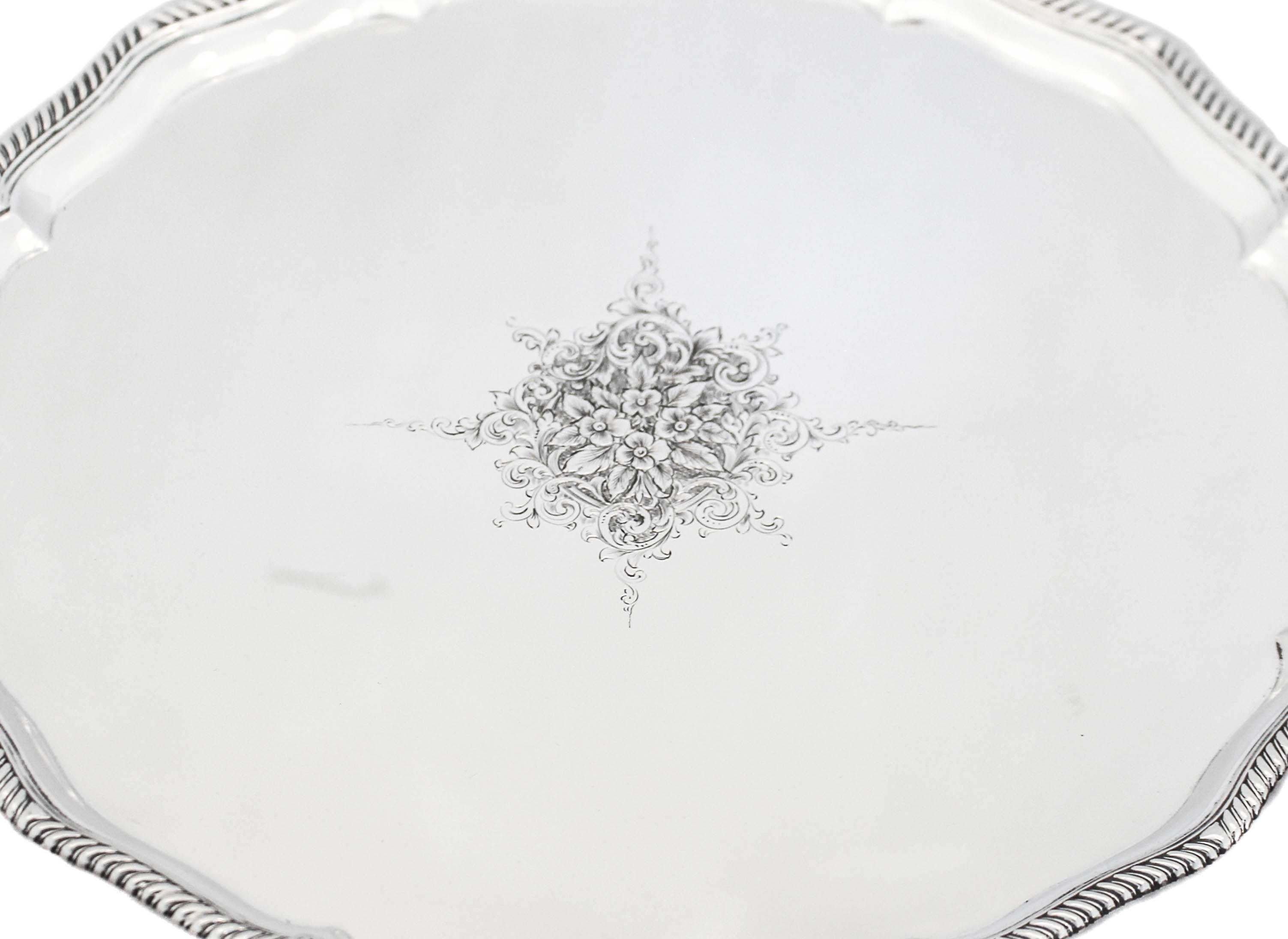 We are proud to offer you this sterling silver salver, hallmarked London 1865.  It stands on four lion paws and has a gadroon wrapping around the scalloped rim.  In the center there is a beautifully etched cluster of flowers design.  This piece can