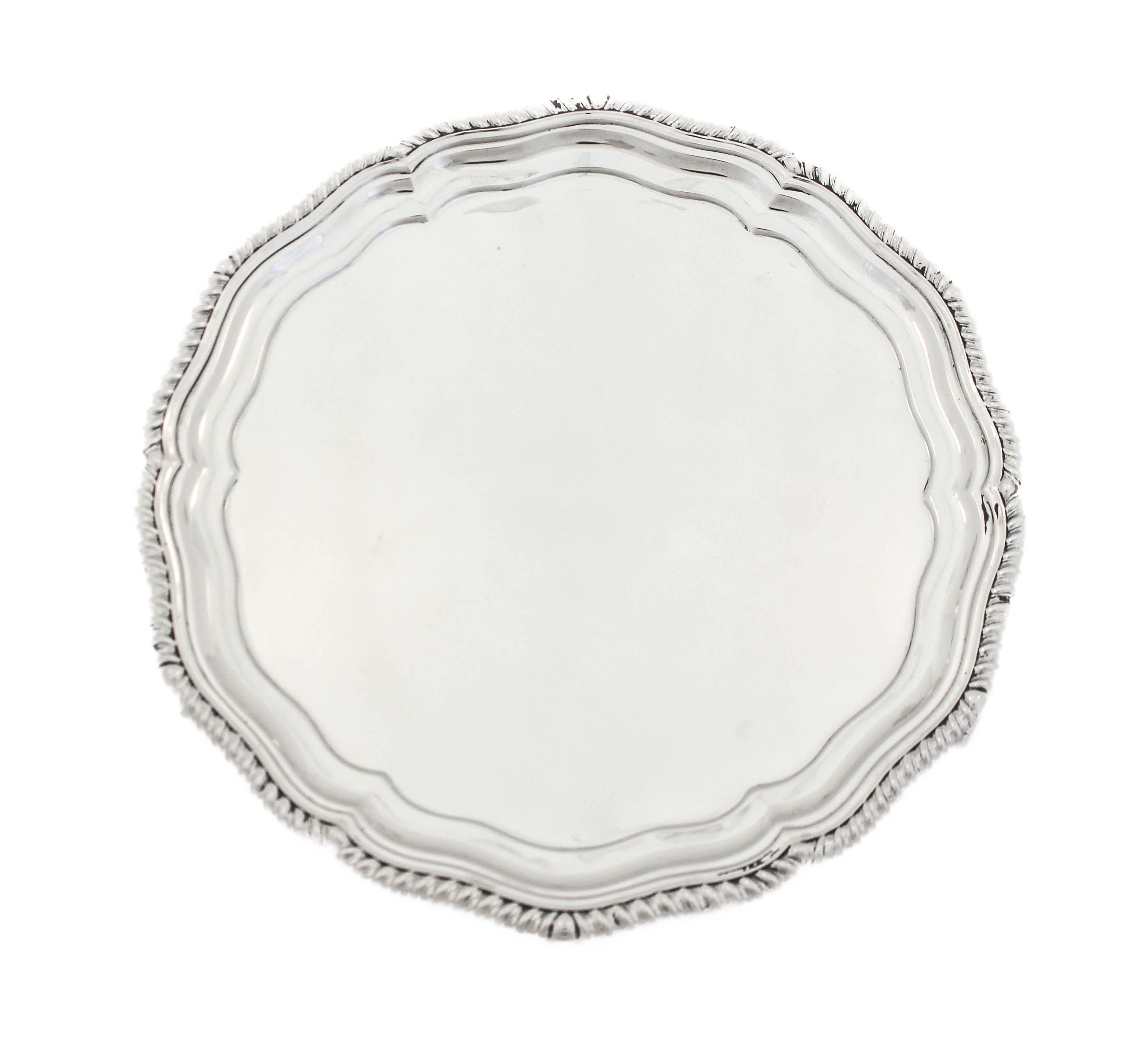 Se ofrece un salvamanteles inglés de plata de ley fabricado por Martin Hall & Company, con matrícula de Sheffield de 1927.
Es festoneado y tiene un diseño de gavilanes alrededor del borde.  El centro es plano, por lo que es ideal para candeleros o