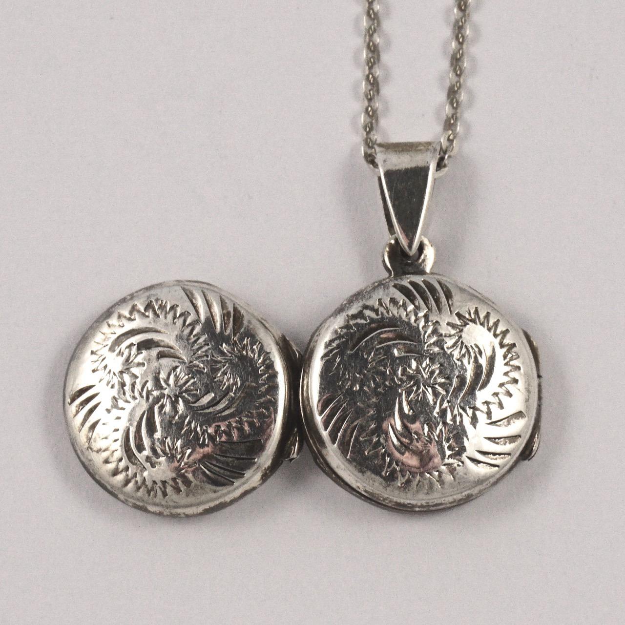 Sterling silver double locket and chain, featuring a lovely engraved abstract leaves design to both sides. The locket measures diameter 1.4cm / .55 inches. There is some scratching as expected. The hinge works well, and the locket closes tightly.