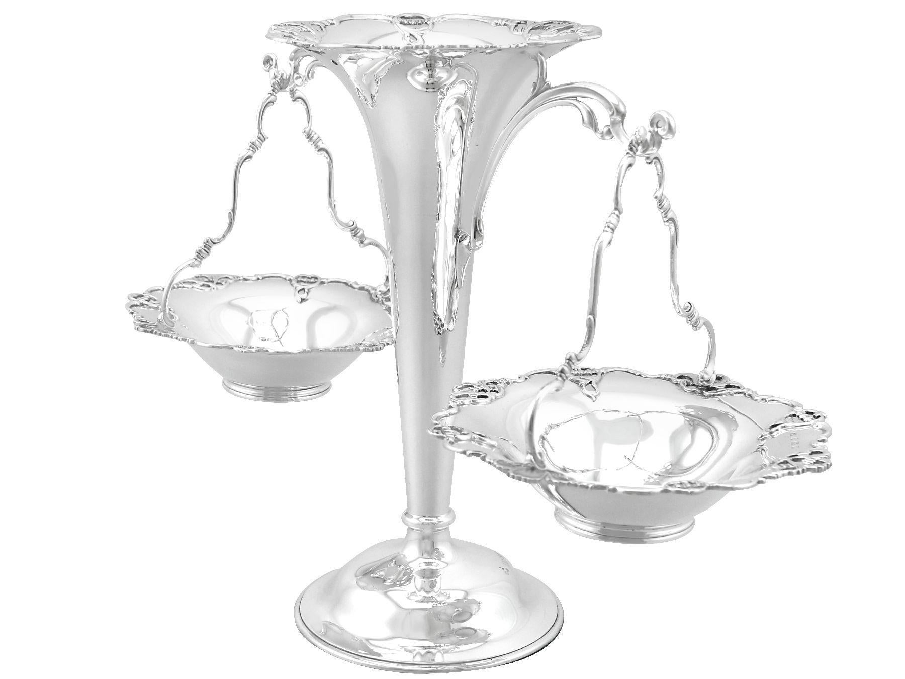 An exceptional, fine and impressive antique George V English sterling silver epergne with hanging baskets; an addition to our ornamental silverware collection.

This exceptional antique George V sterling silver centrepiece/epergne has tapering