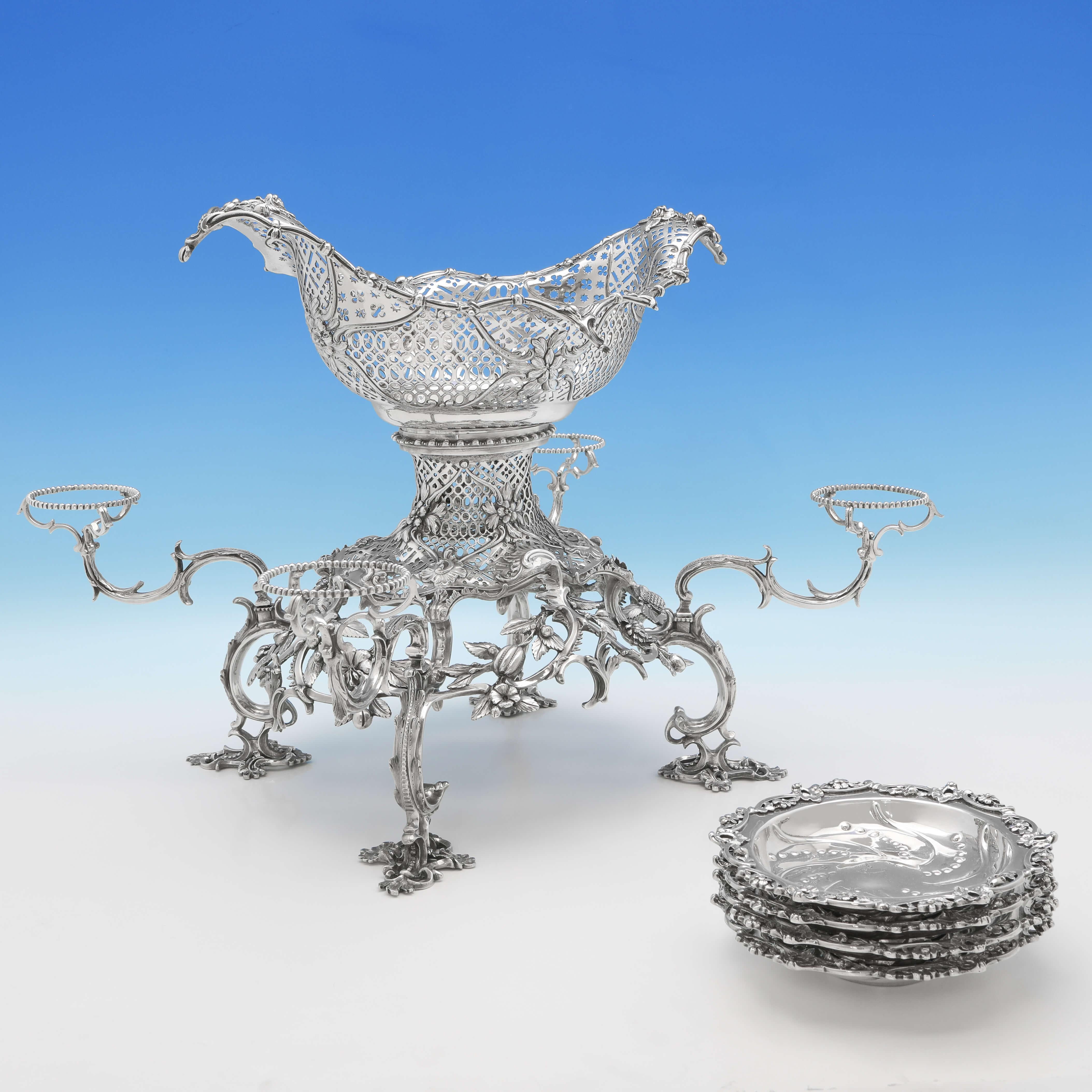 Hallmarked in London, in 1762 by Thomas Pitts, this attractive, George III, antique sterling silver epergne, has four side dishes and a central larger bowl, and is in the rococo style. The epergne measures 13.5 inches (34cm) tall, by 20 inches