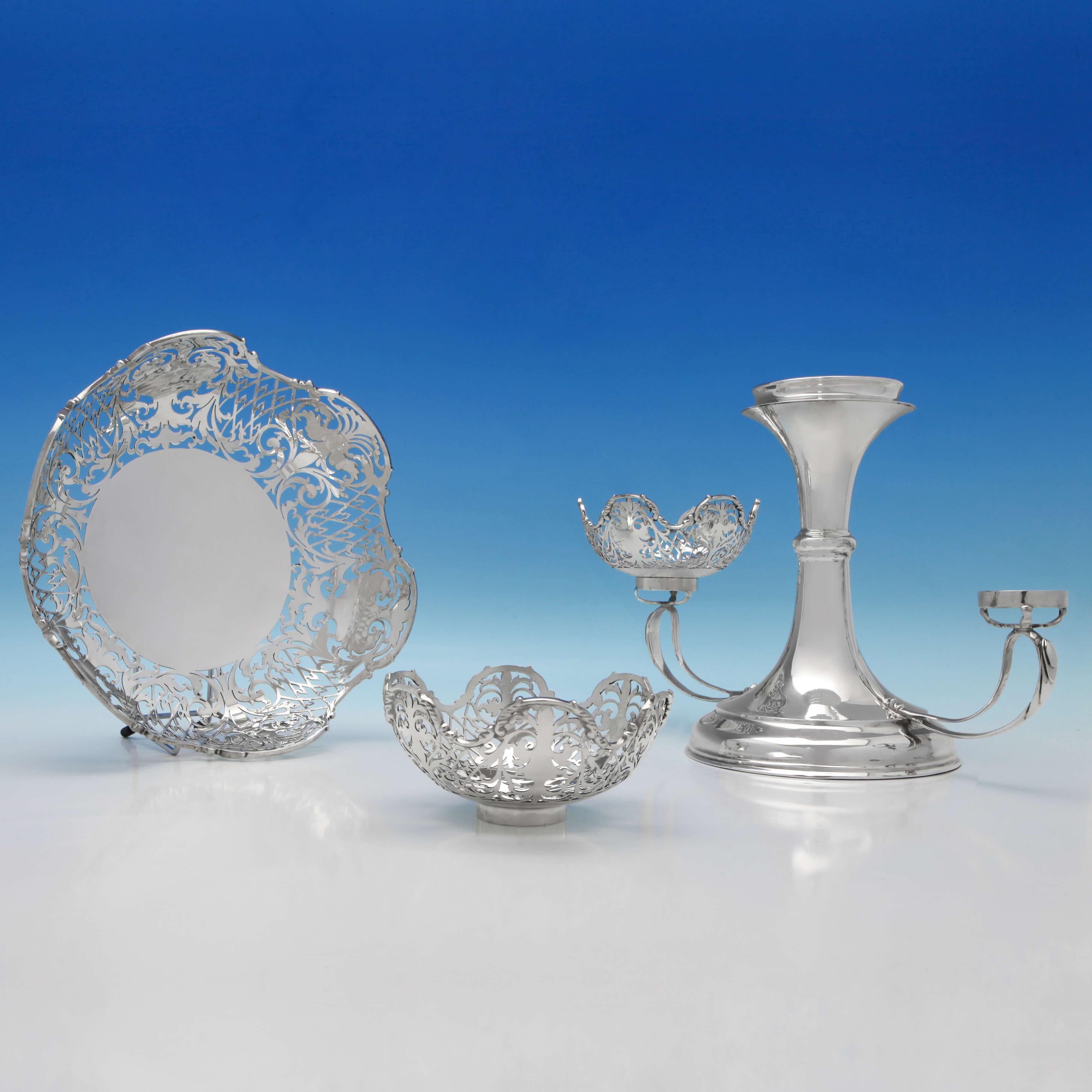 Hallmarked in London in 1906 by Jackson & Fullerton, this charming, Edwardian, antique sterling silver epergne, features a larger central bowl and two smaller side bowls, all with pierced decoration throughout. The epergne measures 11