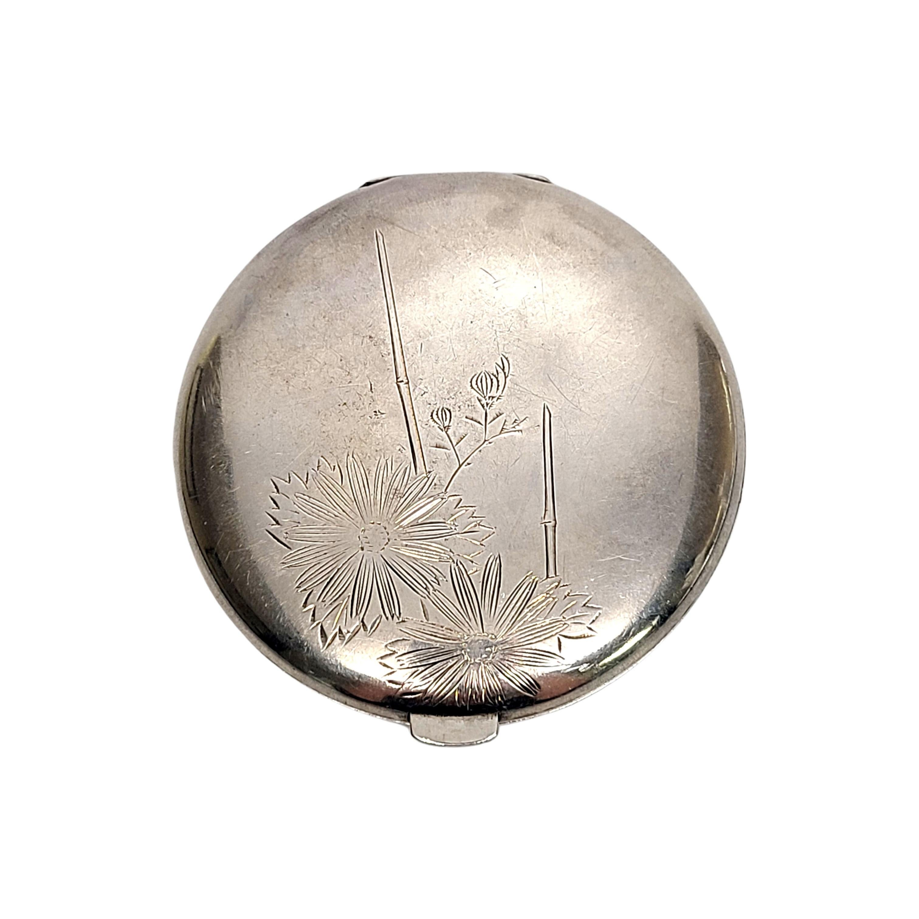 Sterling silver round compact.

Beautiful etched daisy floral motif on both sides. Interior top lid is mirrored, bottom lid has a hinged powder compartment. Push button opening.

No monogram.

Measures 2 7/8