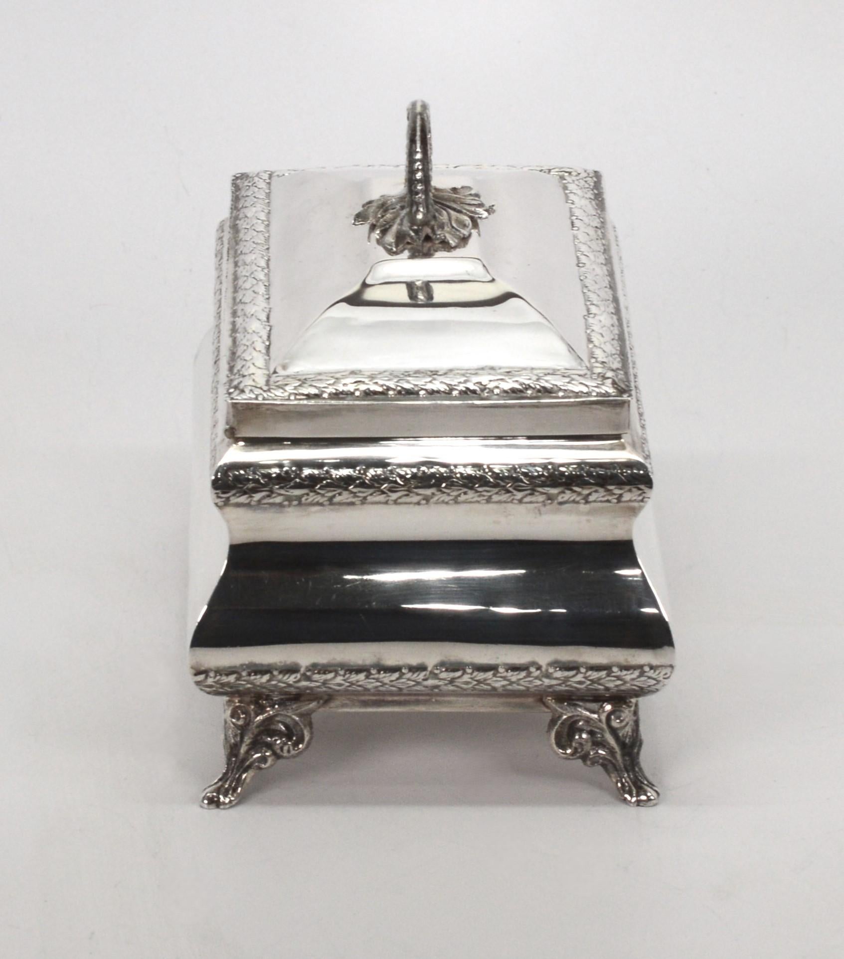 Klassische Linien, handgefertigt aus Sterlingsilber, bilden die Grundlage für diese in Israel hergestellte traditionelle Etrog-Dose. Eine schlichte, repoussierte botanische Bordüre ziert den Deckel  und benennt den Körper des von der Truhe