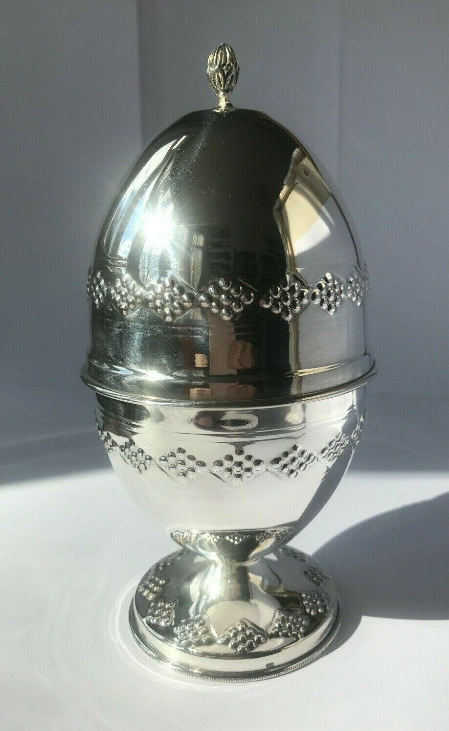 Sterling Silver Etrog Holder

In good vintage condition, this is a beautiful piece. It has a small ding on the top.

It is  an egg-shaped box and consists of a base with a pedestal foot and a lid with a pitam on top.

Both parts are decorated with