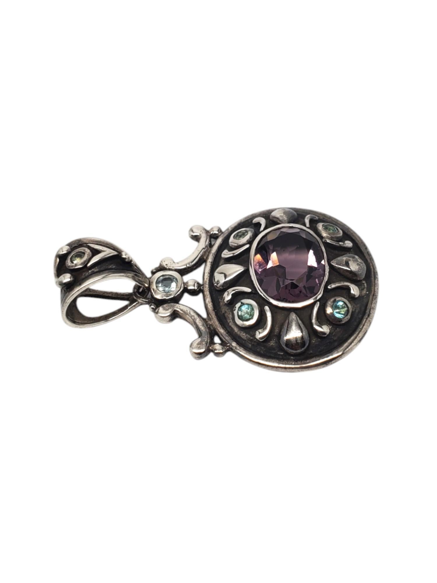 Ciondolo con gemma viola sfaccettata in argento 925 - A. Silver

Questo bellissimo ciondolo presenta una gemma viola sfaccettata di forma ovale (12,7 mm x 16,7 mm) in un castone rialzato e 5 pietre blu rotonde incastonate nell'argento sterling con