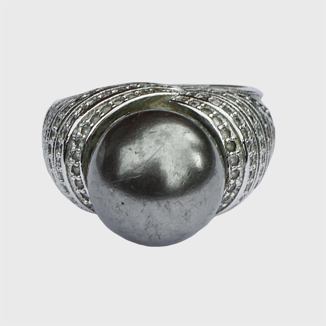 Bellissimo anello da cocktail in argento sterling, con incastonata una grande perla finta grigio scuro, circondata da strass chiari e blu scuro.

Misura dell'anello UK Q / US 8. Diametro interno 1,95 cm. La finta perla presenta dei graffi.

Questo