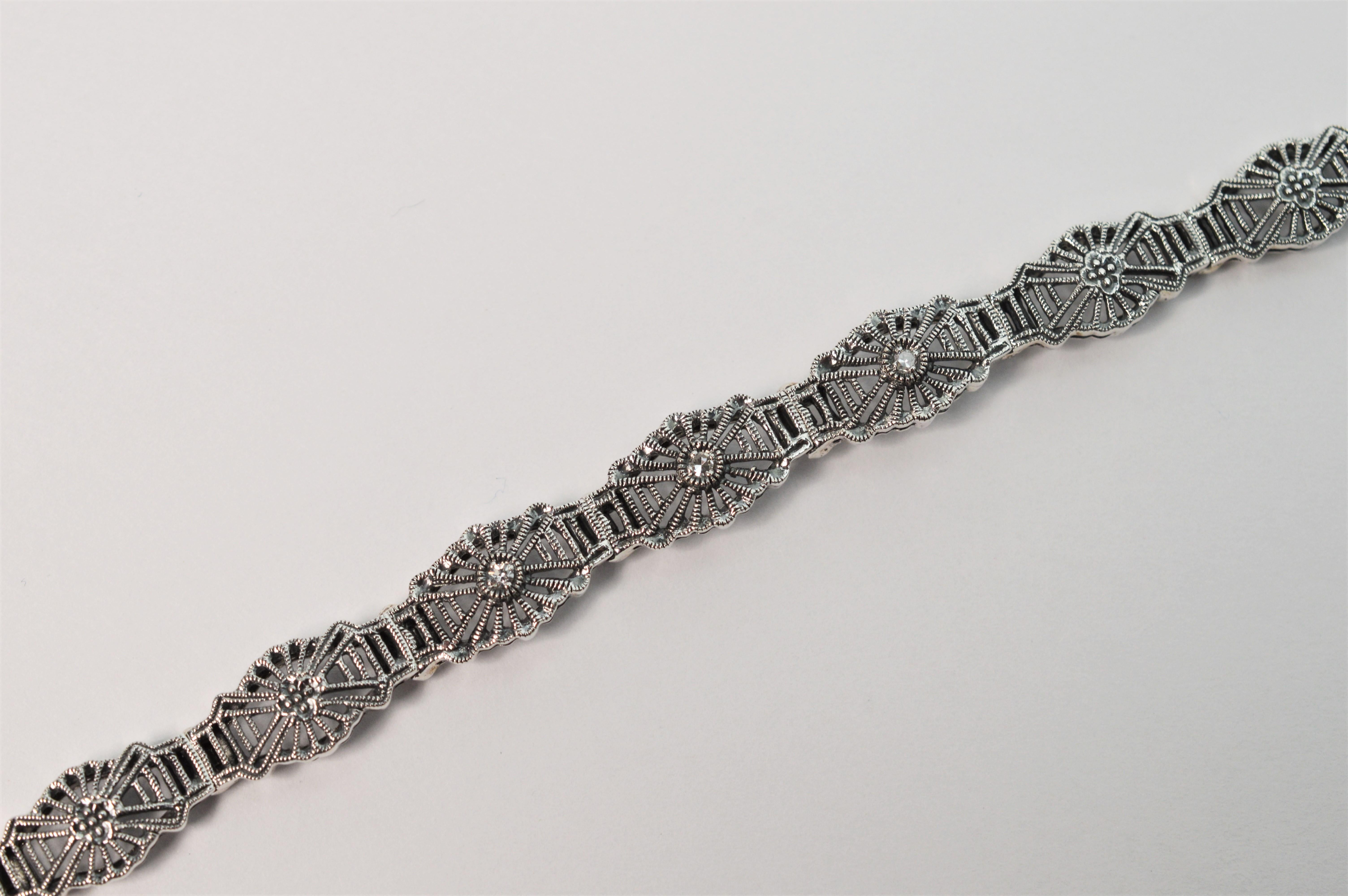 Three diamond accents highlight the front of this romantic Art Deco Style sterling silver filigree link bracelet. This new, vintage inspired bracelet is 7.5 inches in length 
and approximately 2/8 inch wide. Individual links of delicate sterling