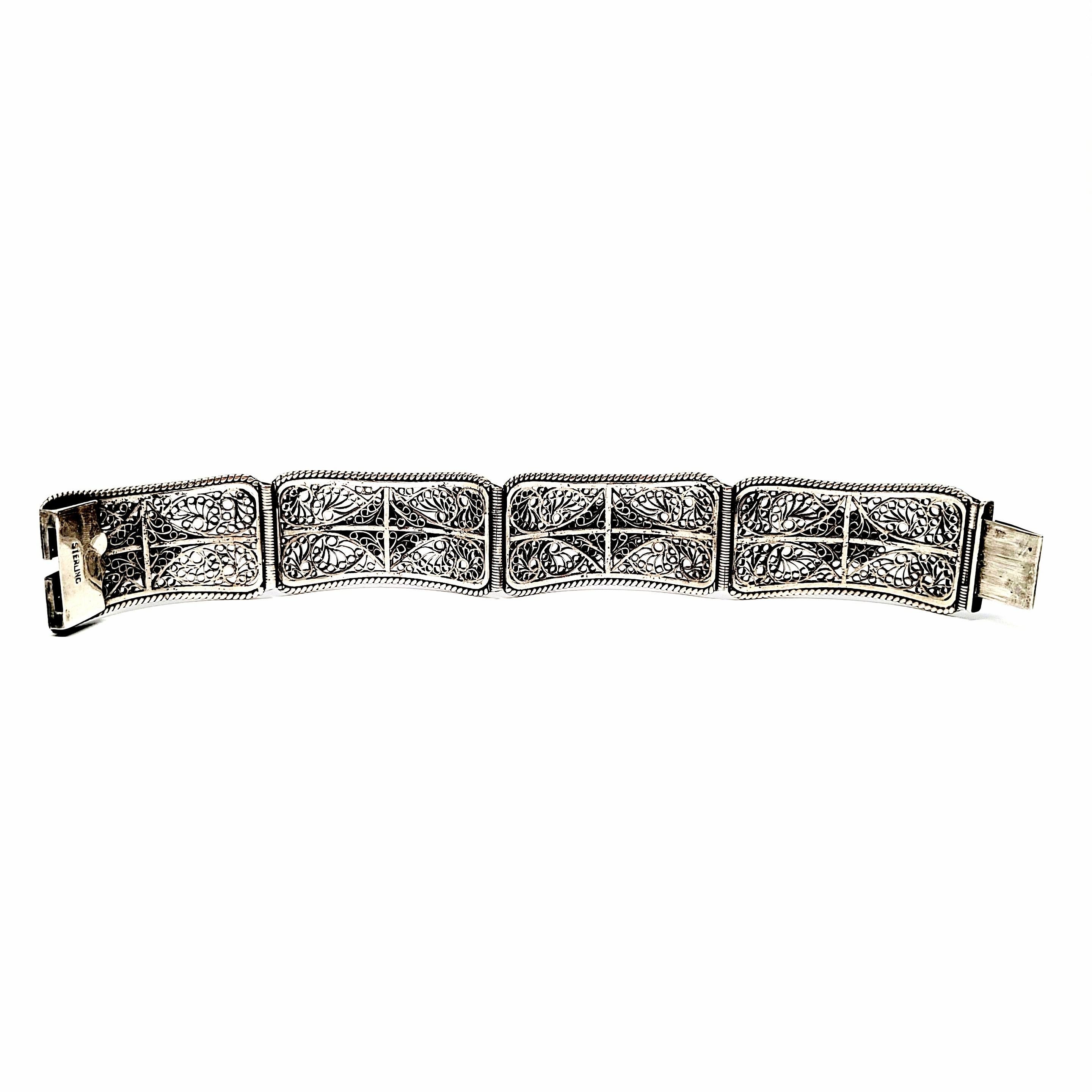 Sterling silver filigree panel bracelet.

4 panel bracelet featuring filigree design and beaded and rope accent applied design. Slide push clasp closure.

Measures approx 6 1/2