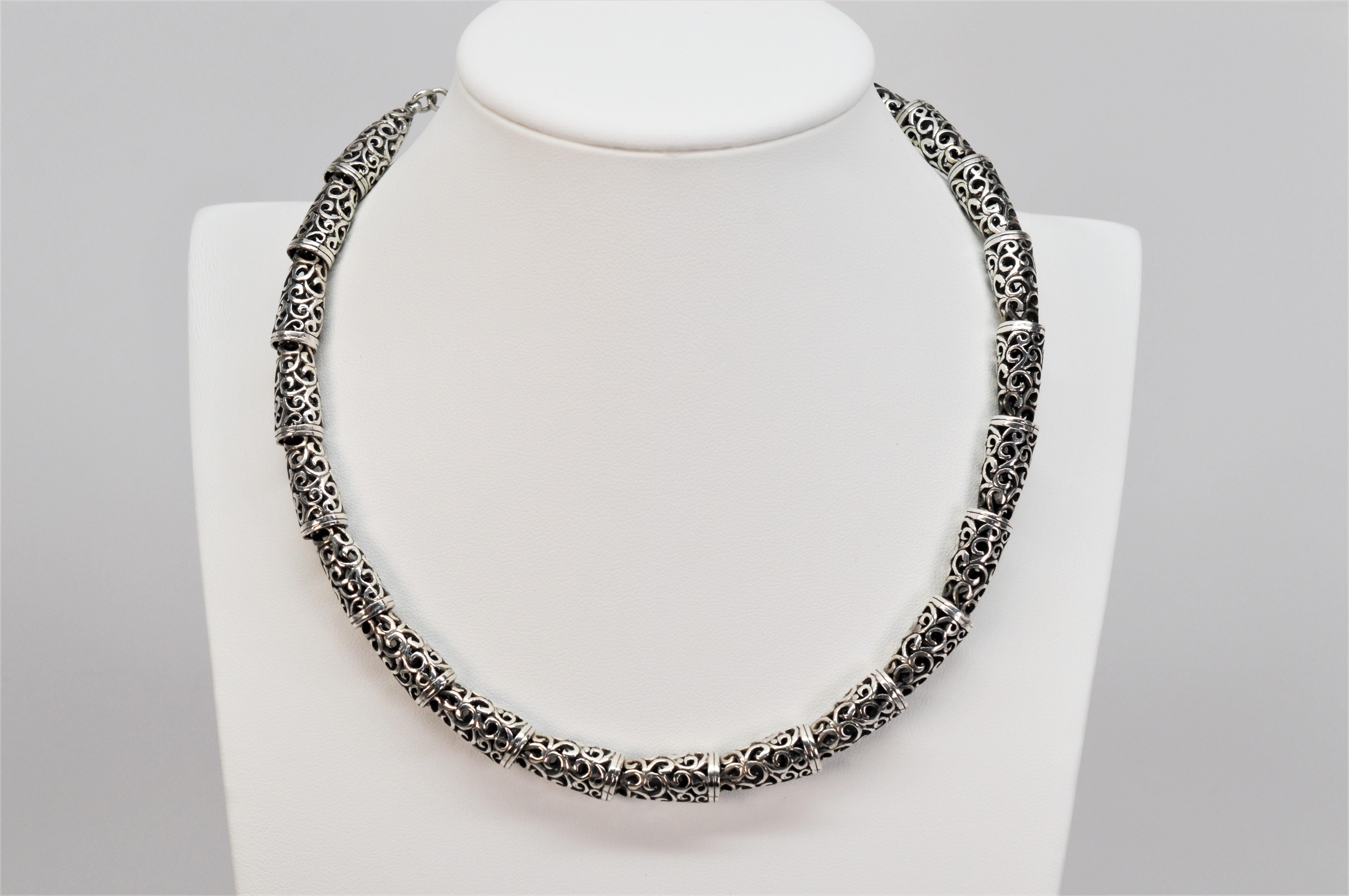 A decorative scroll pattern in individual sterling silver links create this artful collar necklace. The cut out shadow pattern adds artful dimension to this interesting silver piece. Adjustable 15 - 17 inch in length, an easy toggle clasp with